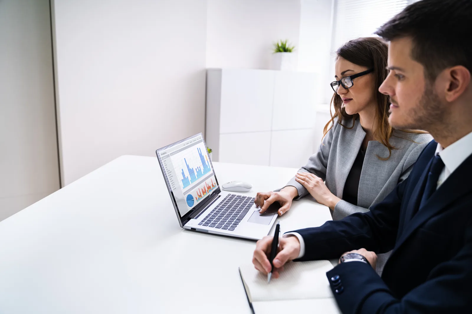 Litigation support team reviewing a document review queue and legal hold dashboard together on a laptop in their office