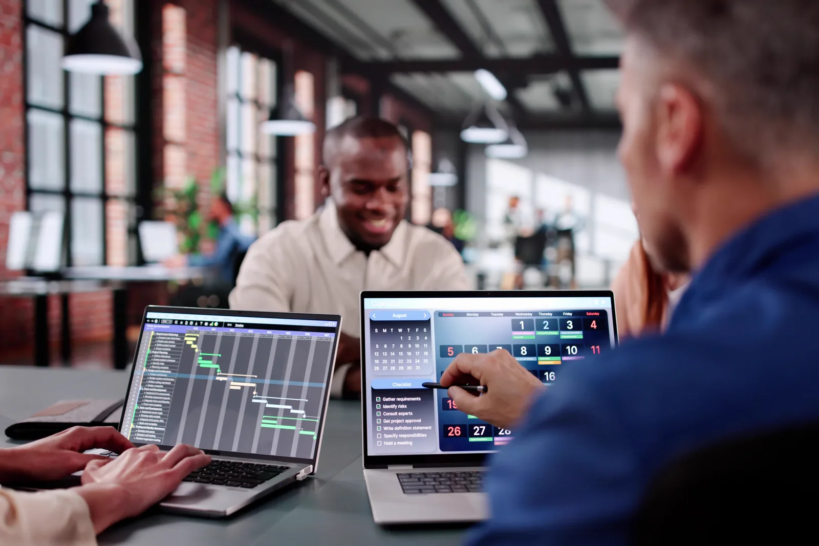 Software team reviewing an electrical job estimate and panel schedule together at a laptop in their office