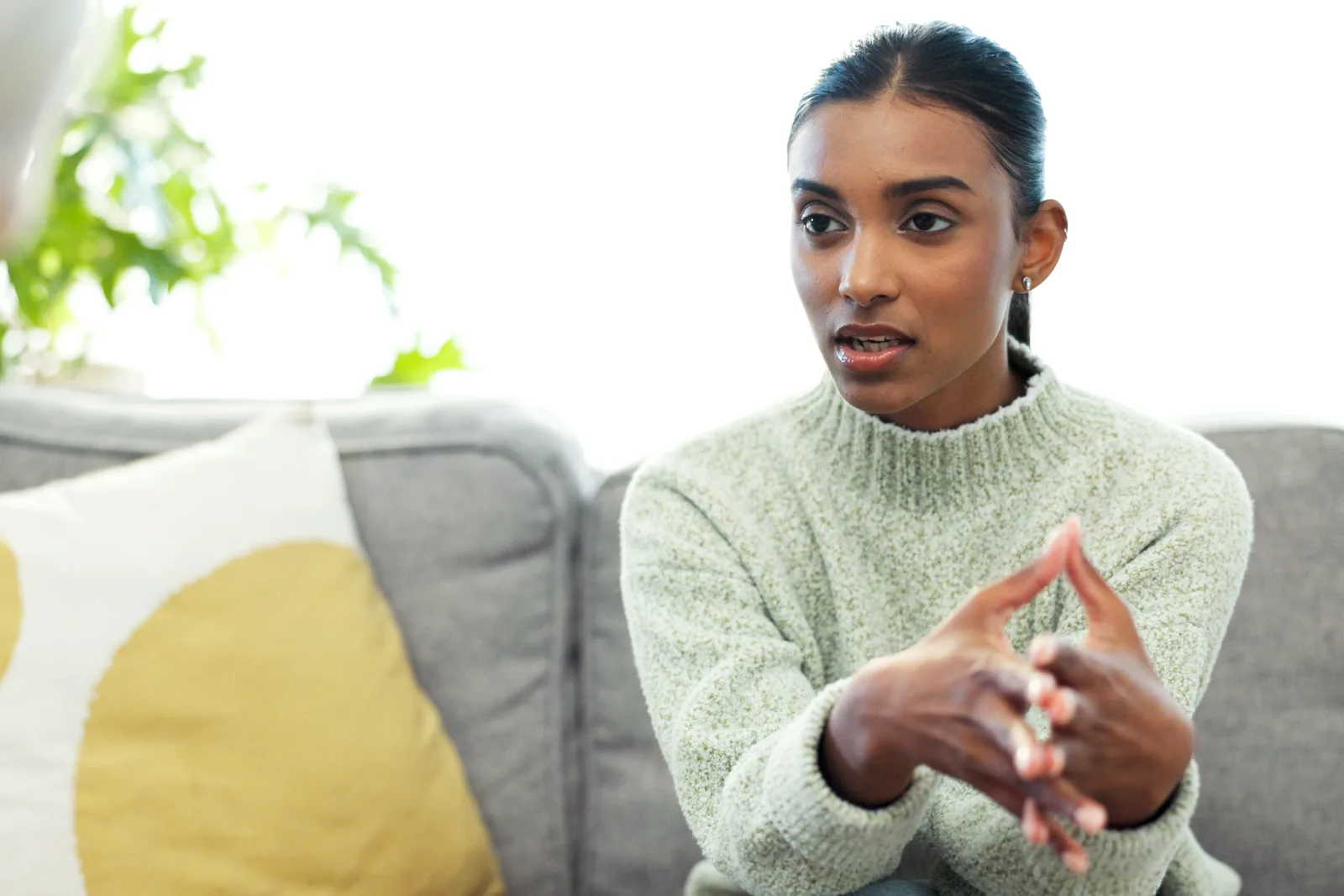 Therapist and client talking together in a calm, softly lit counseling office during a trauma therapy session