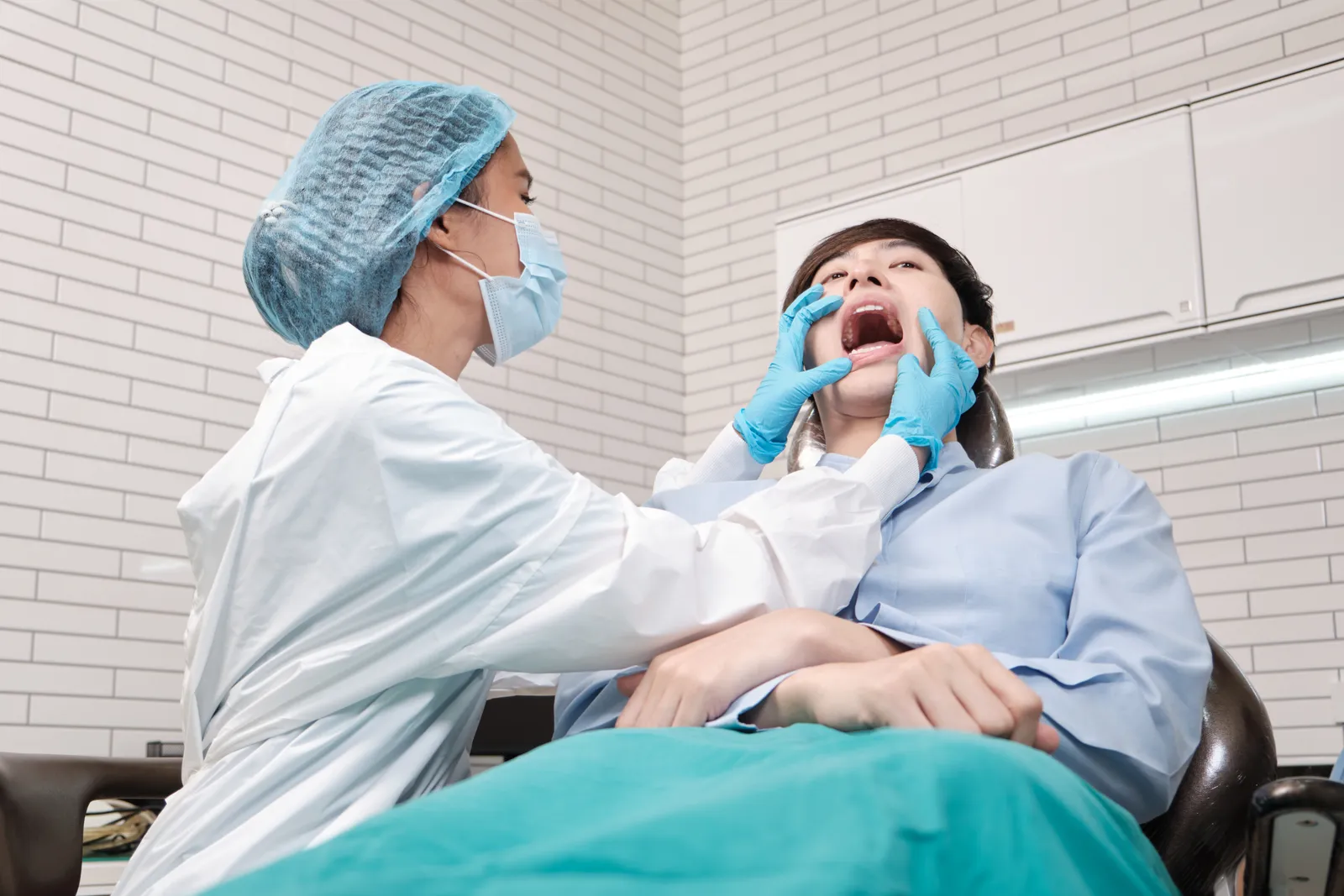 Emergency dentist examining a patient's painful tooth during a same-day urgent care visit