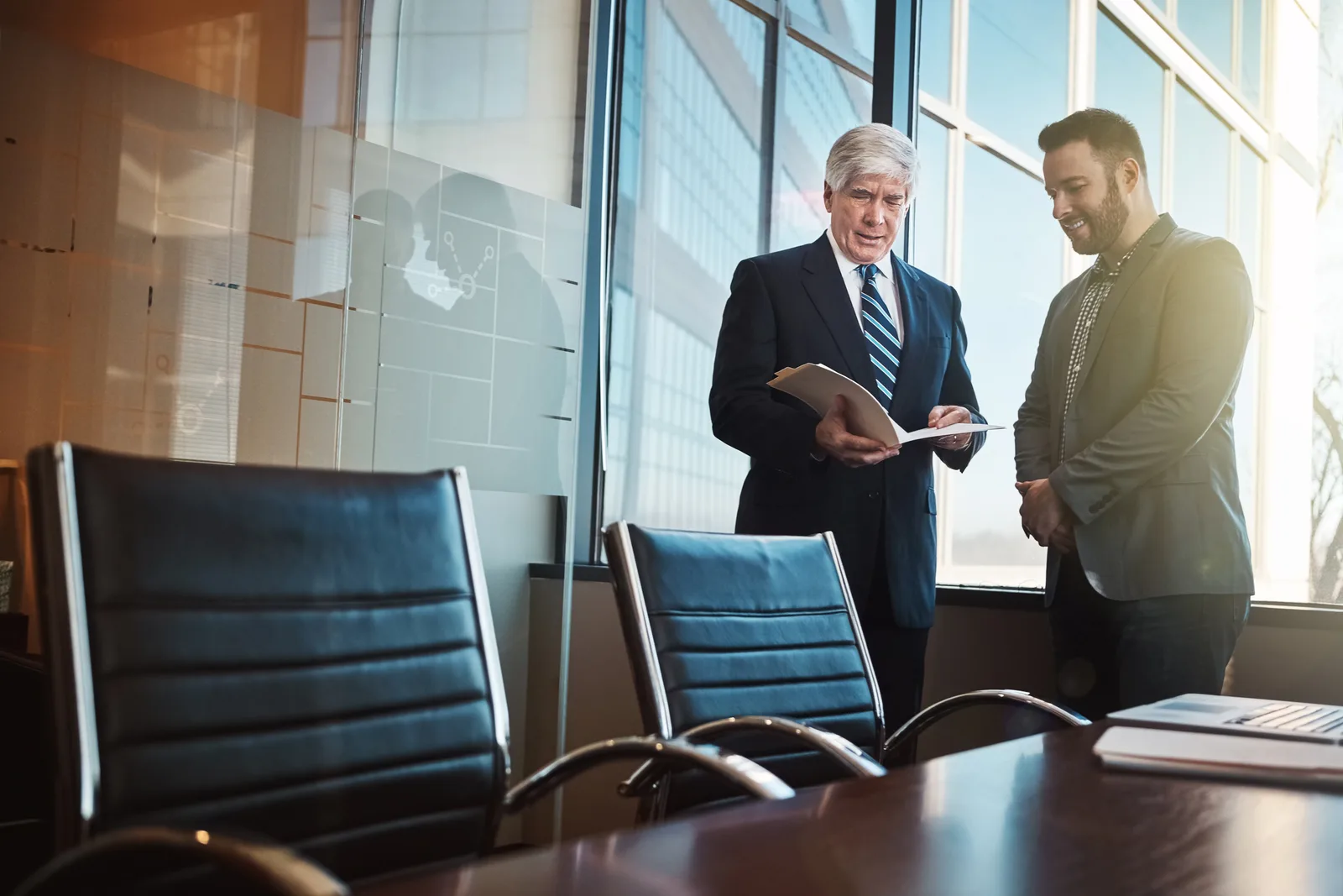 Employment defense attorney meeting with an HR director at a conference table, reviewing an EEOC charge response