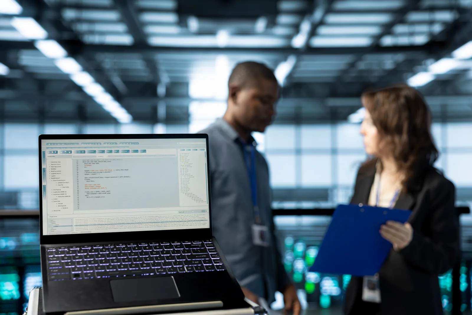 Endpoint security engineers reviewing a threat-detection dashboard covering a fleet of devices together at a laptop in their office