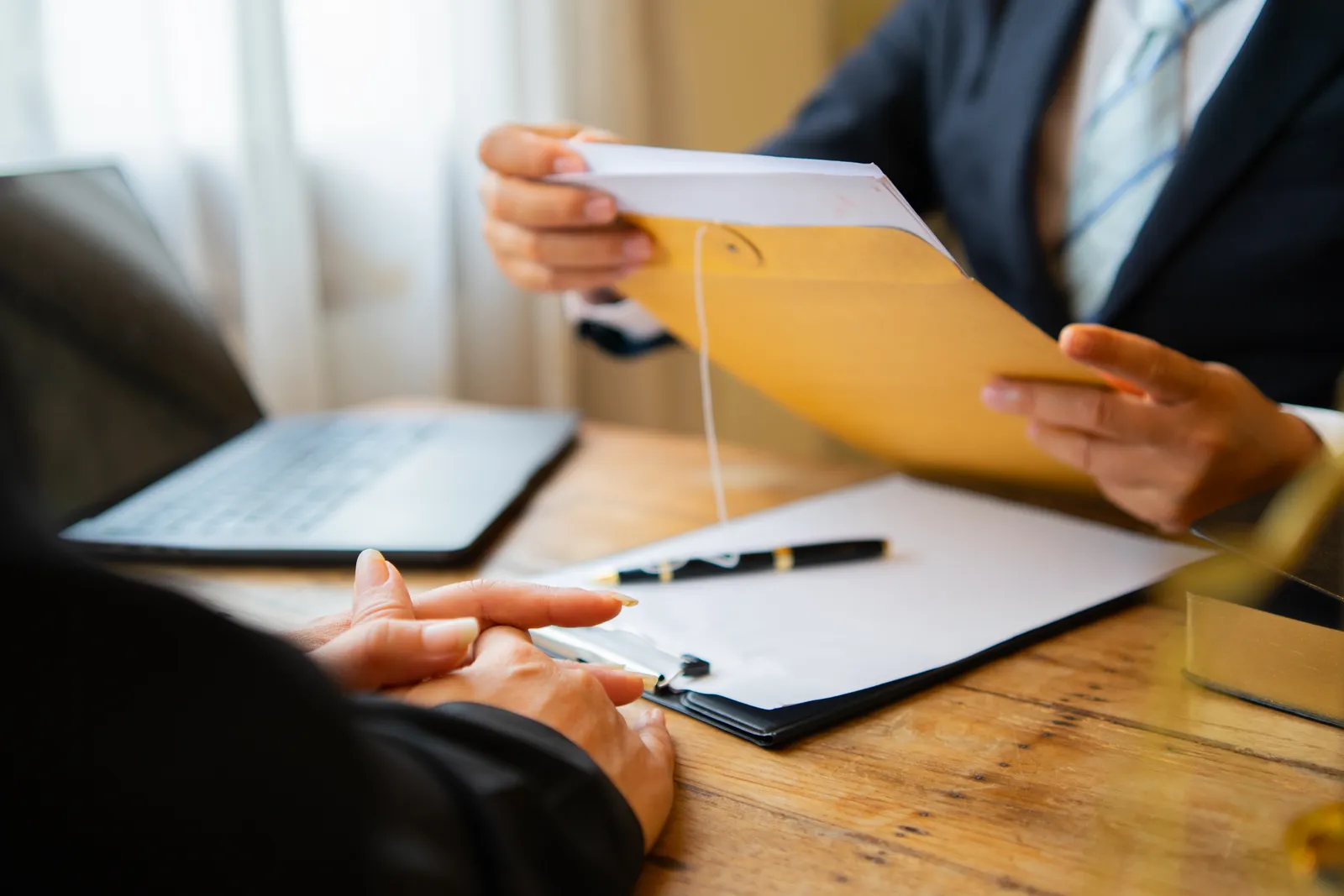 ERISA attorney reviewing a denied benefits claim and plan documents with a client at his office desk