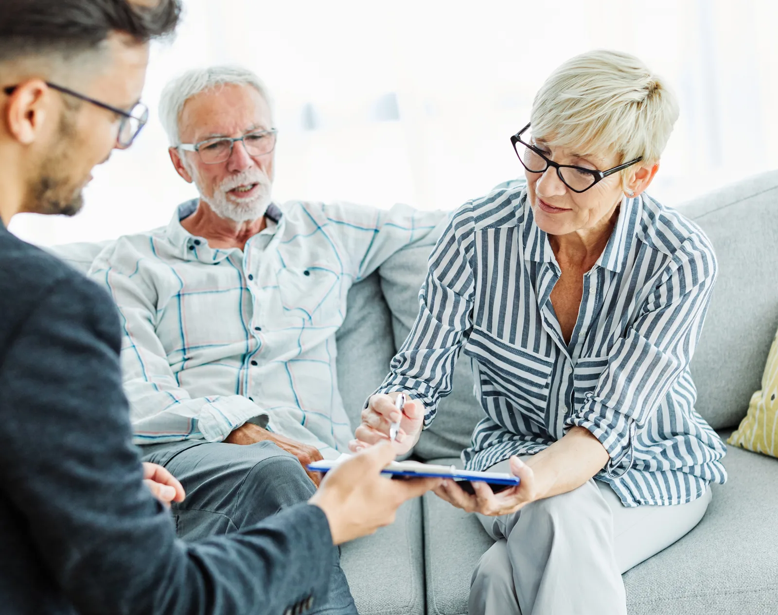 Estate planning attorney walking a retired couple through their will and trust documents at an office conference table