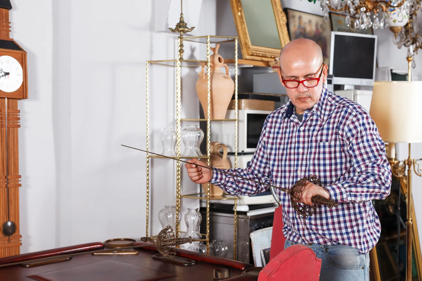 Estate sale company owner tagging antique furniture and household items for sale inside a family's living room