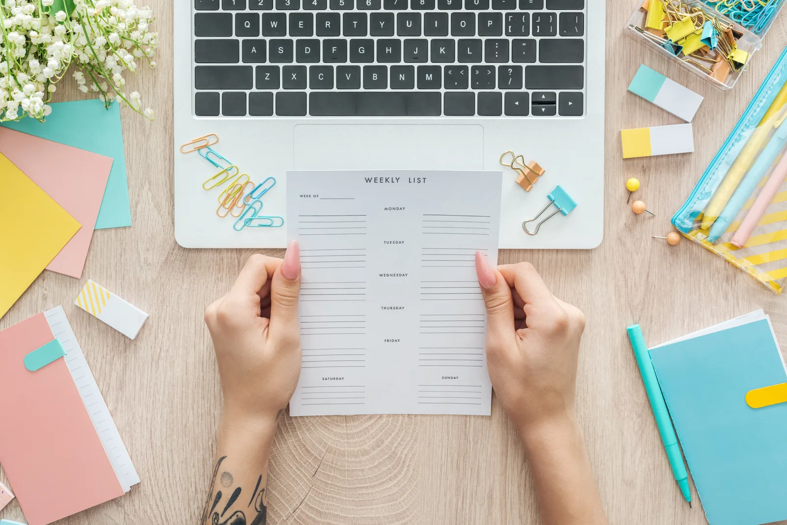 Etsy shop owner designing a printable planner template on a laptop, with styled mockup pages laid out on the desk
