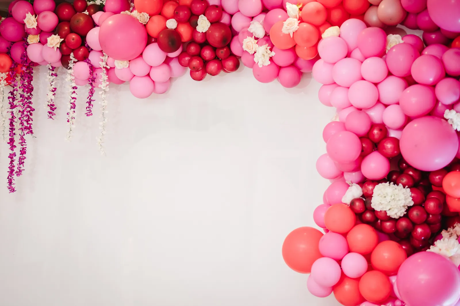 Pink balloon garland arching over an event backdrop