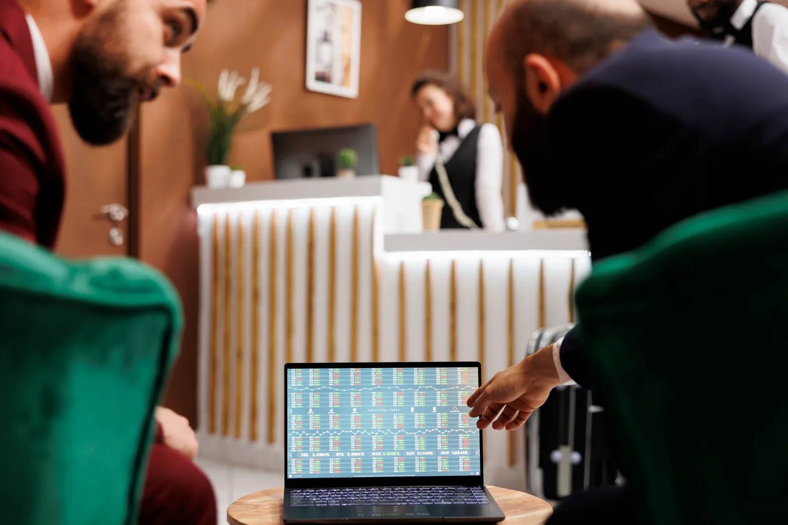 Event operations team reviewing live registration and check-in numbers together on a laptop before a conference