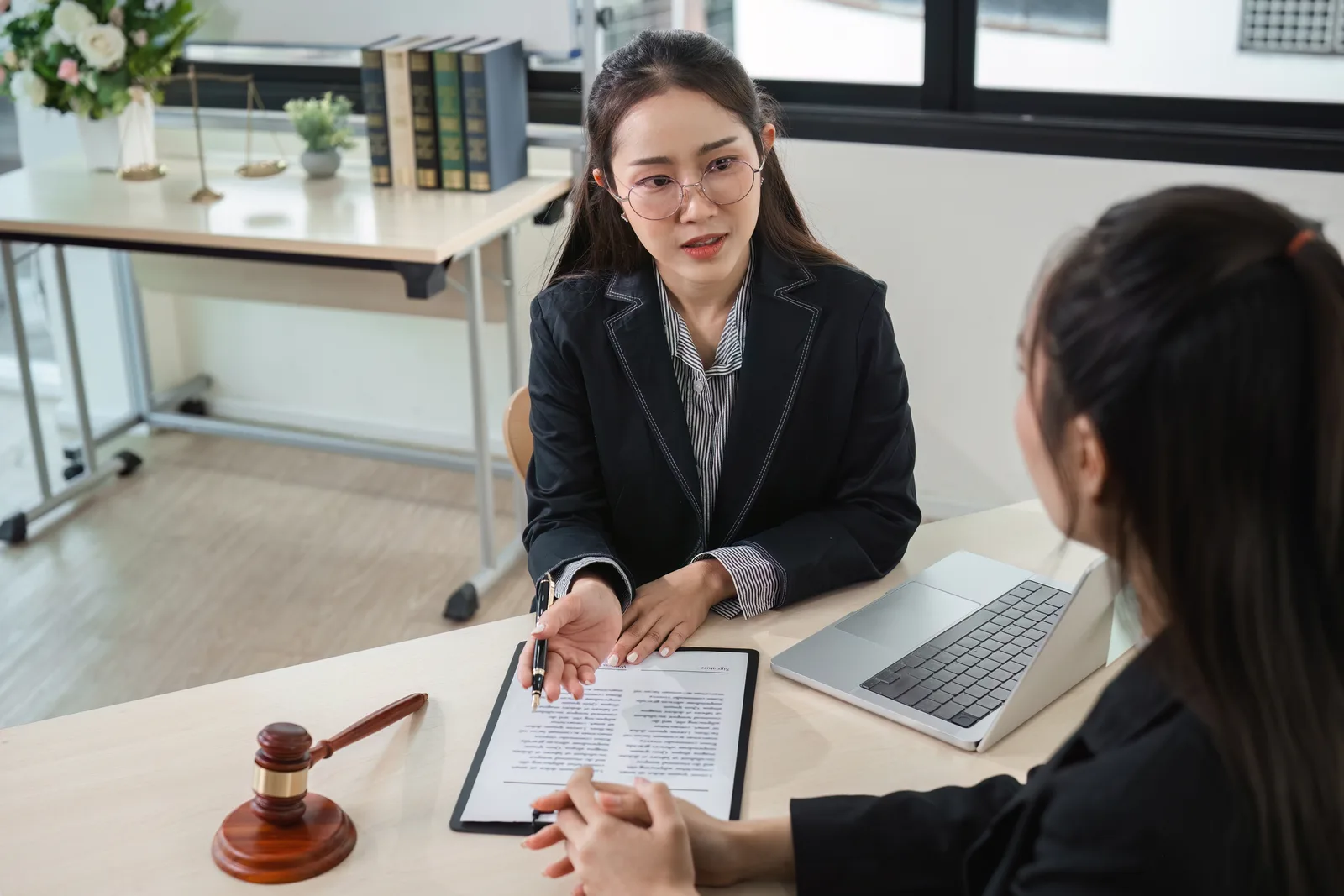 Expungement attorney reviewing a client's criminal record documents together at her desk