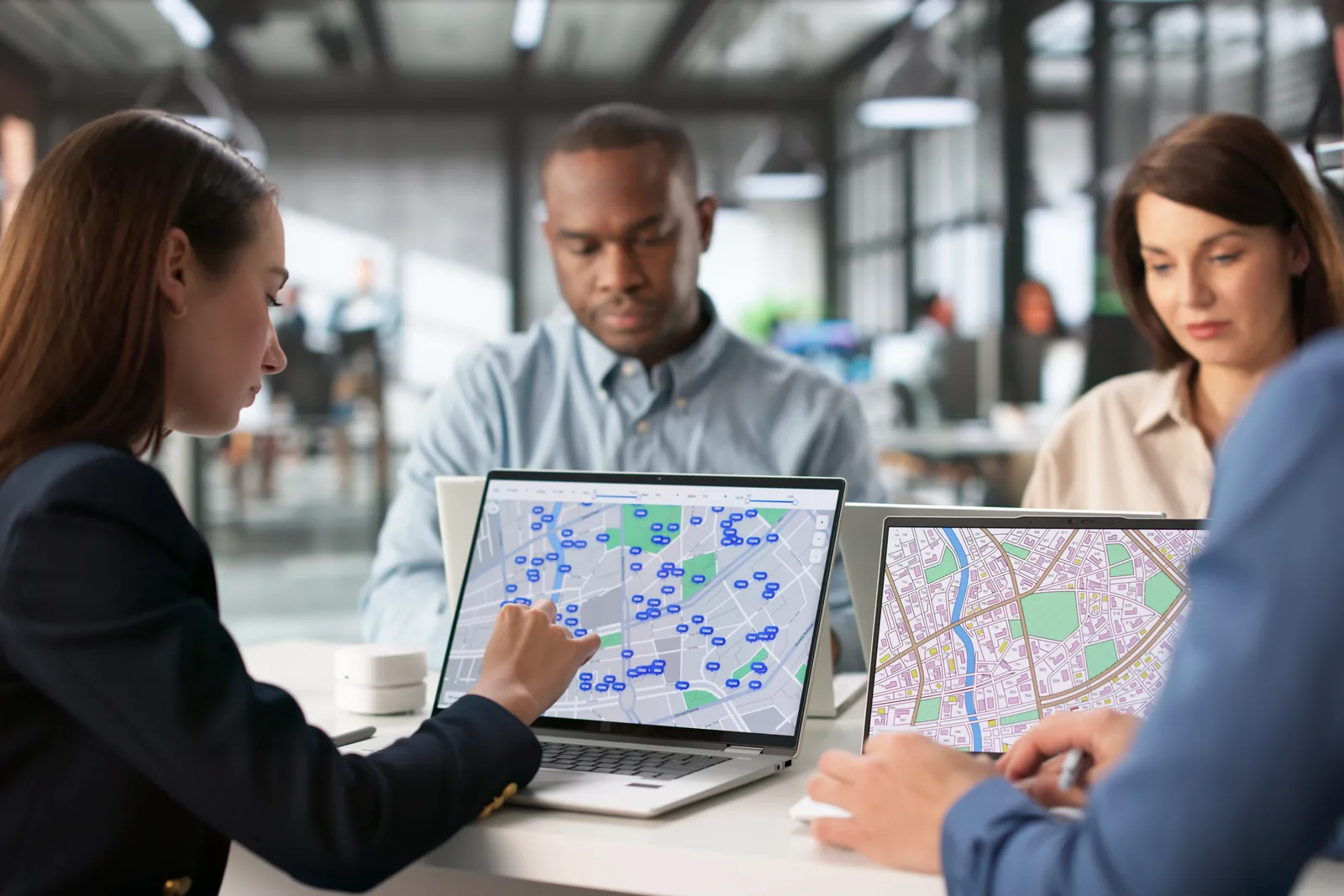 Software team reviewing a field map and crop yield dashboard together at a laptop in their office