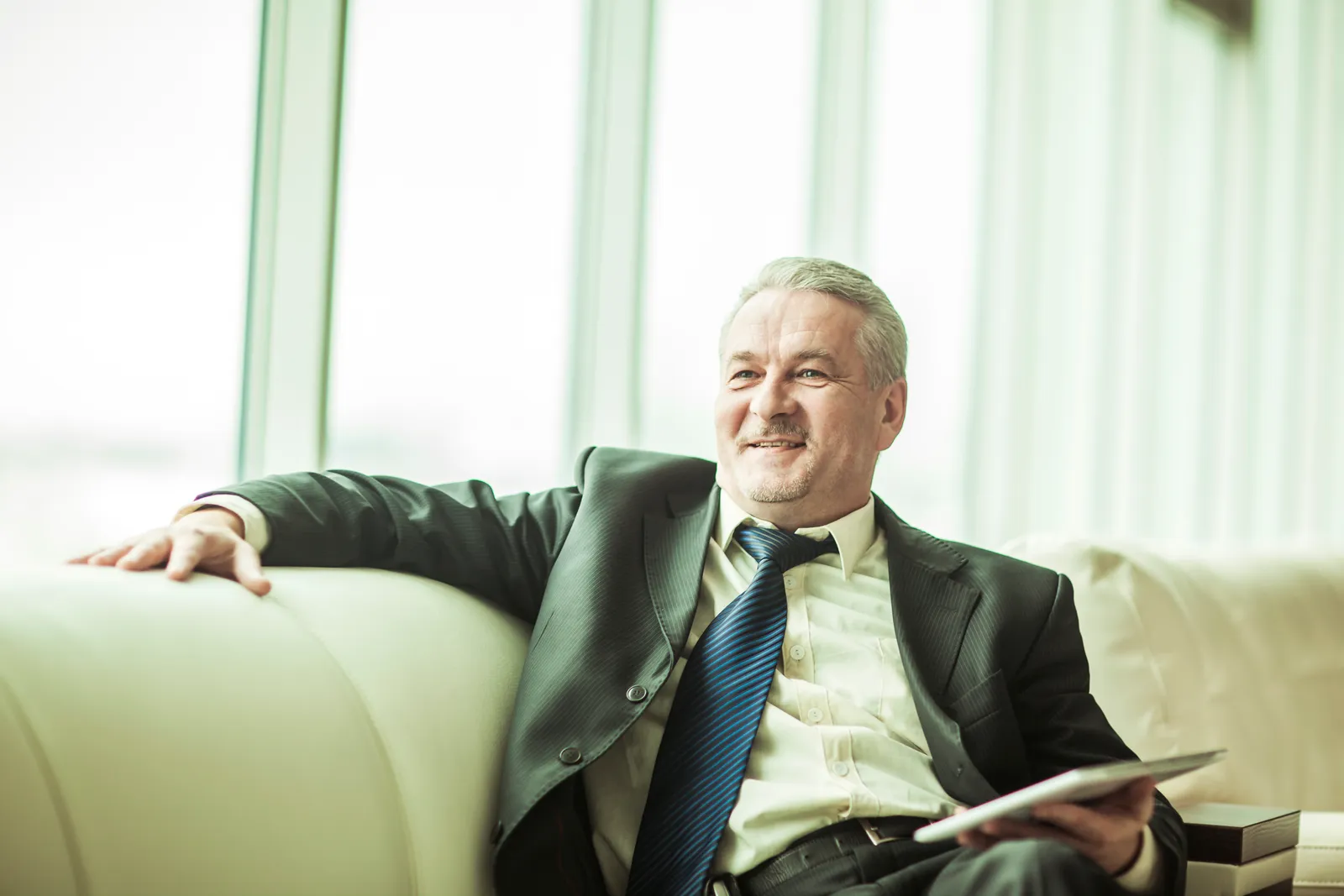 Fashion brand counsel reviewing an agreement on a tablet in a showroom lounge