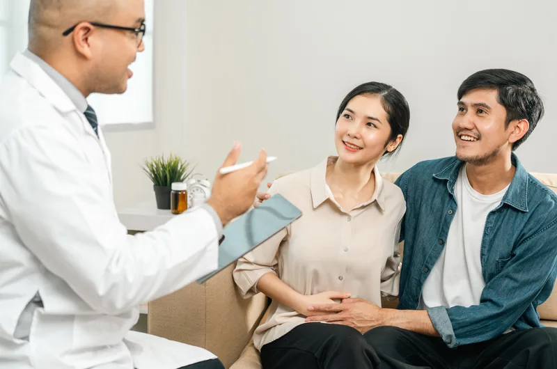 Hopeful couple consulting a doctor about IVF at a fertility clinic