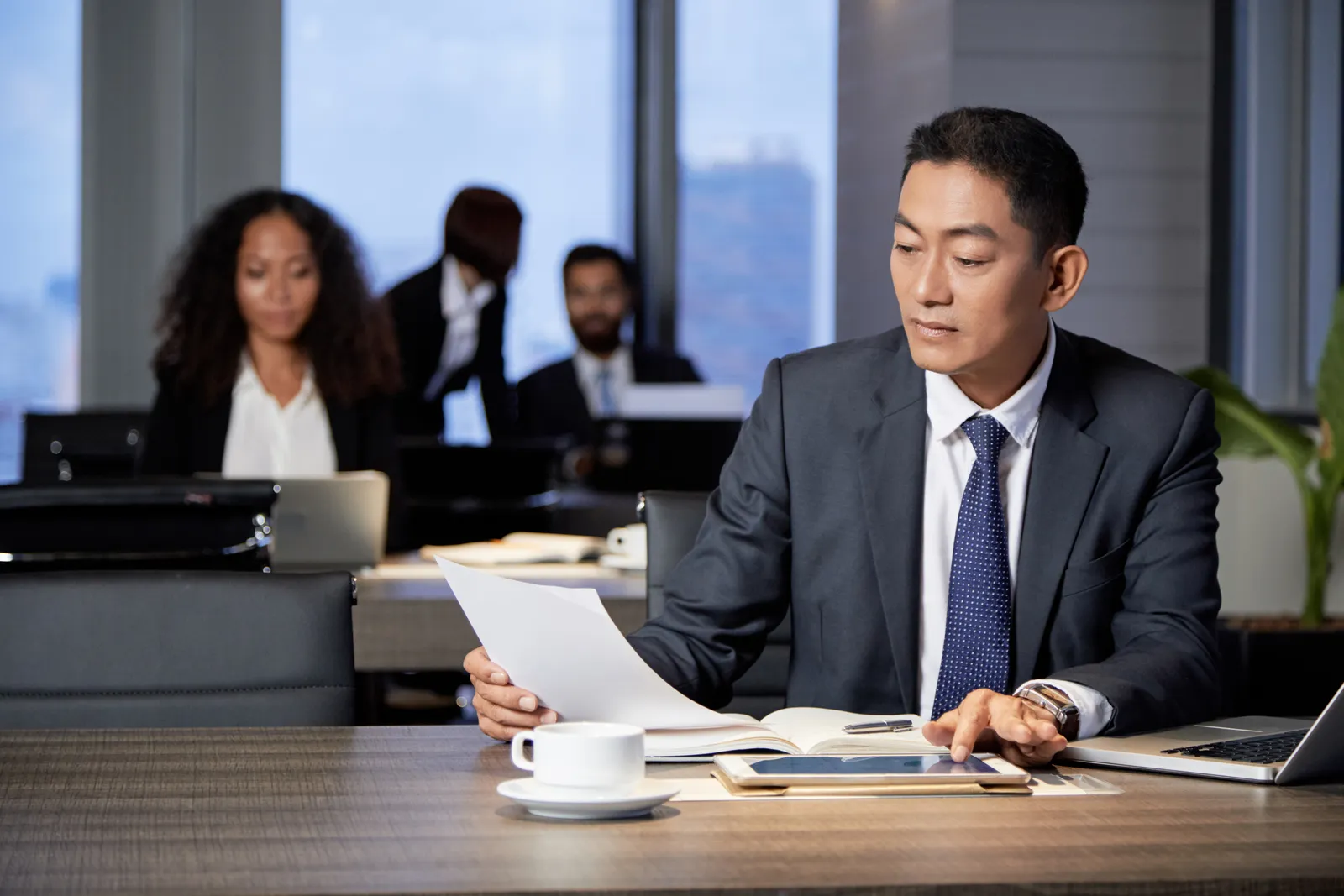 Fintech attorney reviewing a state money-transmitter license application with a payments company founder at a conference table