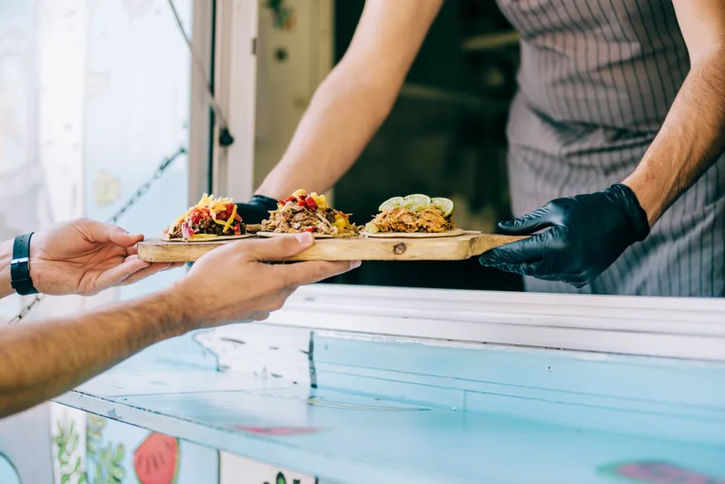 Food truck owner serving a customer