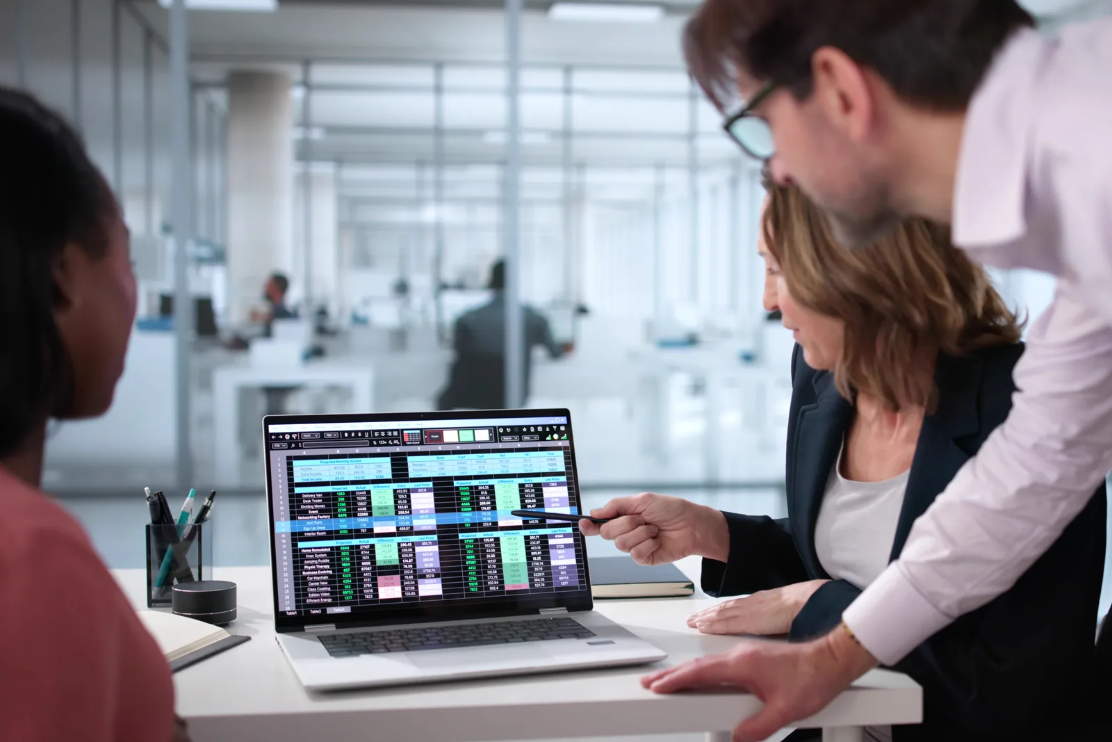 Freight brokerage team reviewing live loads and carrier rates together on a laptop dashboard
