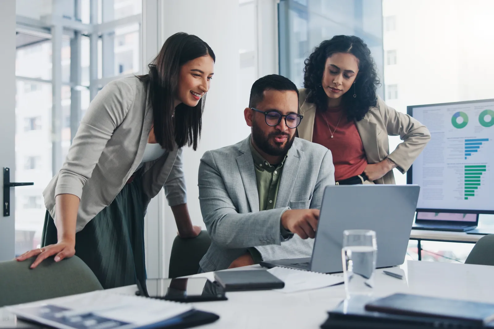 Generative AI product team reviewing signup and generation metrics together on a laptop in their office