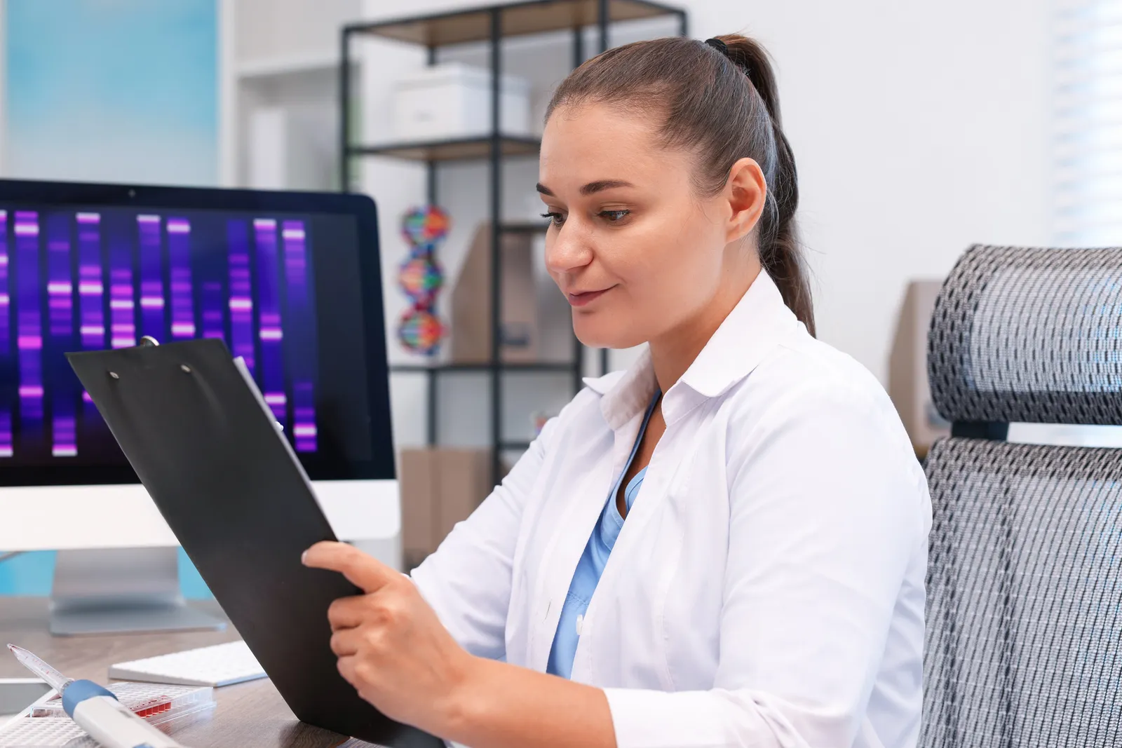 Genetic counselor reviewing a DNA test results report with a patient in a clinic office