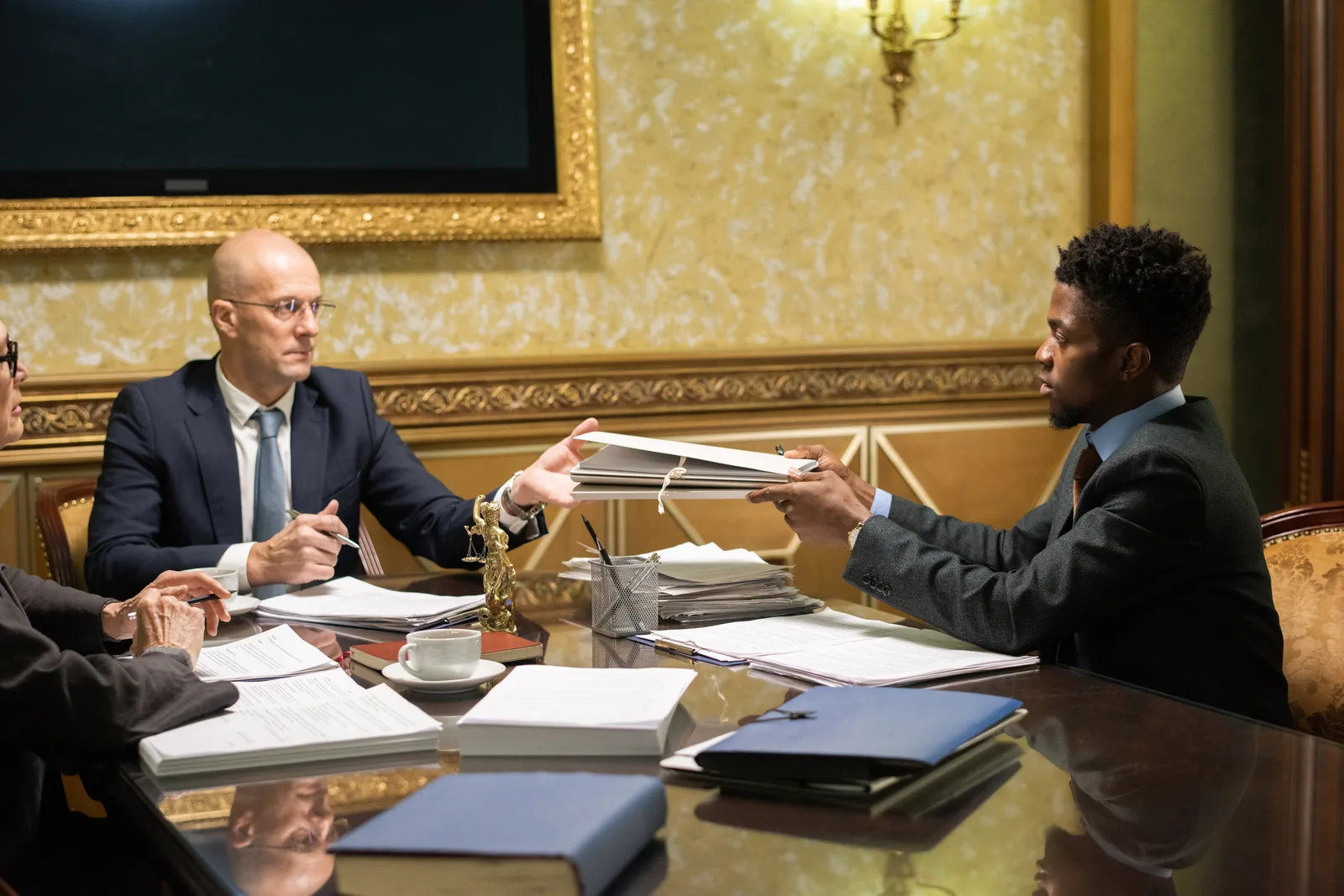 Government contracts attorney reviewing a bid protest filing with a small business contractor client at a conference table