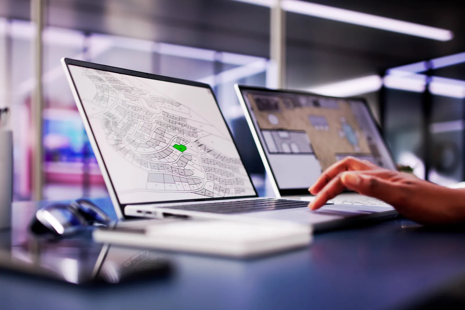 Government permitting staff reviewing an online permit application and inspection workflow on a laptop in a city office
