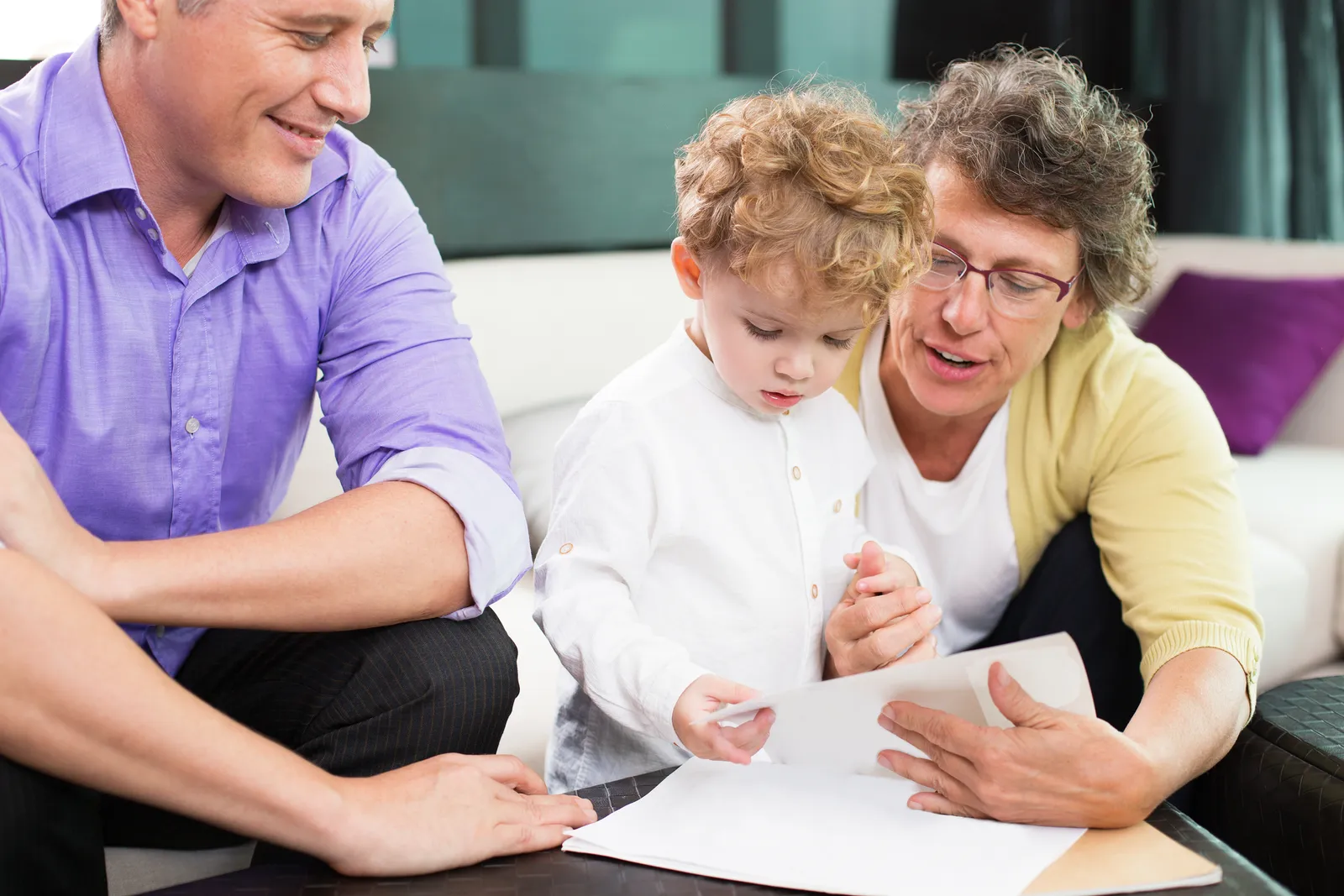 Guardianship attorney sitting with a grandmother and her grandchild at a desk, reviewing guardianship petition paperwork