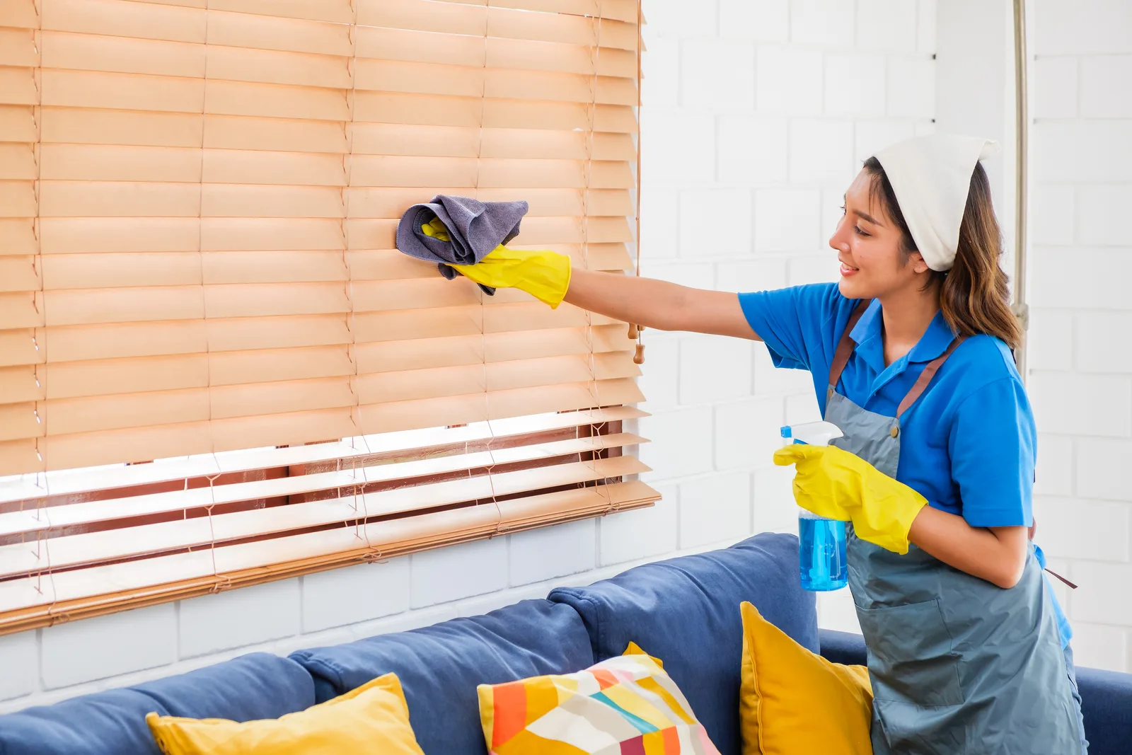 House cleaner tidying the living room of a client's home during a scheduled visit