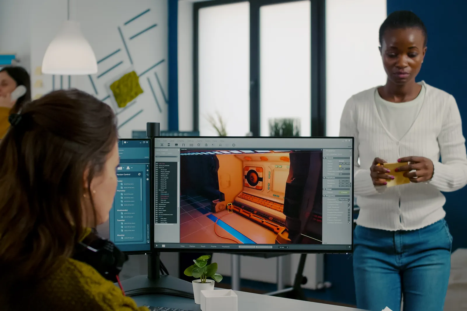 Hyper-casual game studio team playtesting a prototype and reviewing install and retention data together at a monitor in their studio