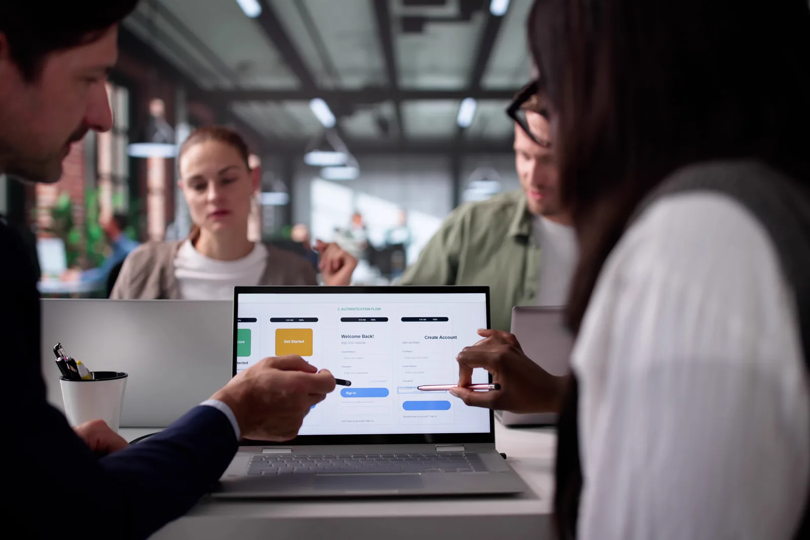 IAM software team reviewing single sign-on and access policy dashboards together on a laptop in their office