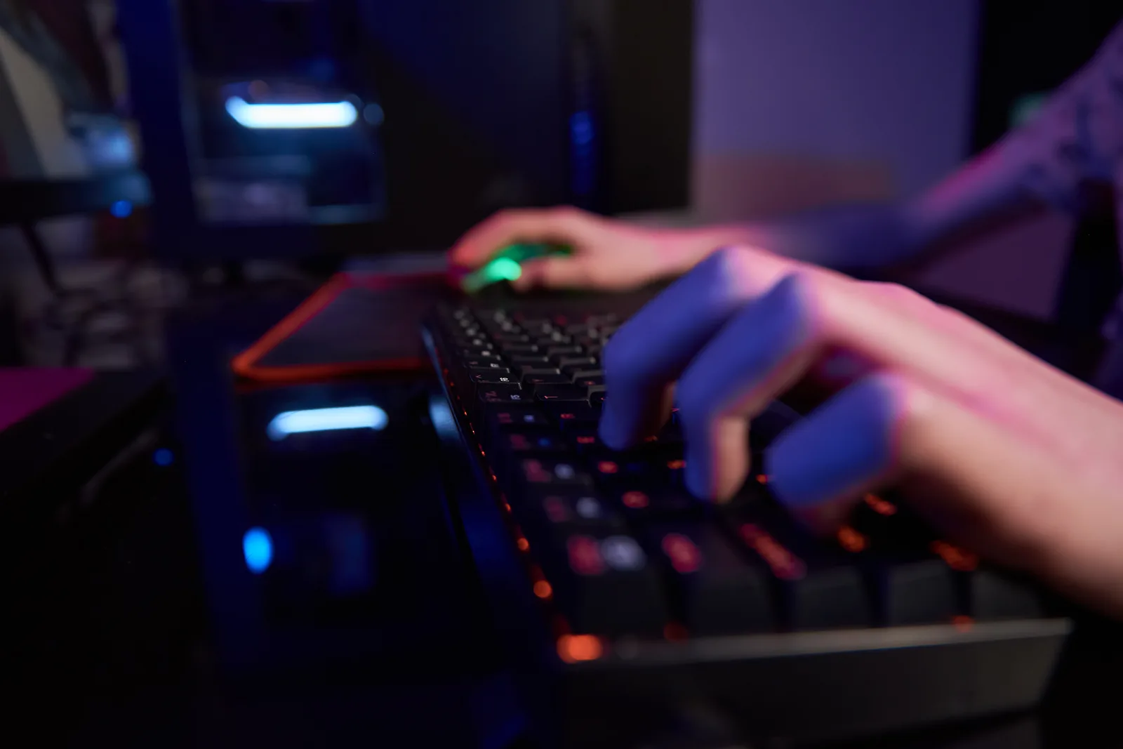 Indie game developers at a small studio desk reviewing their Steam store page and wishlist chart on a laptop