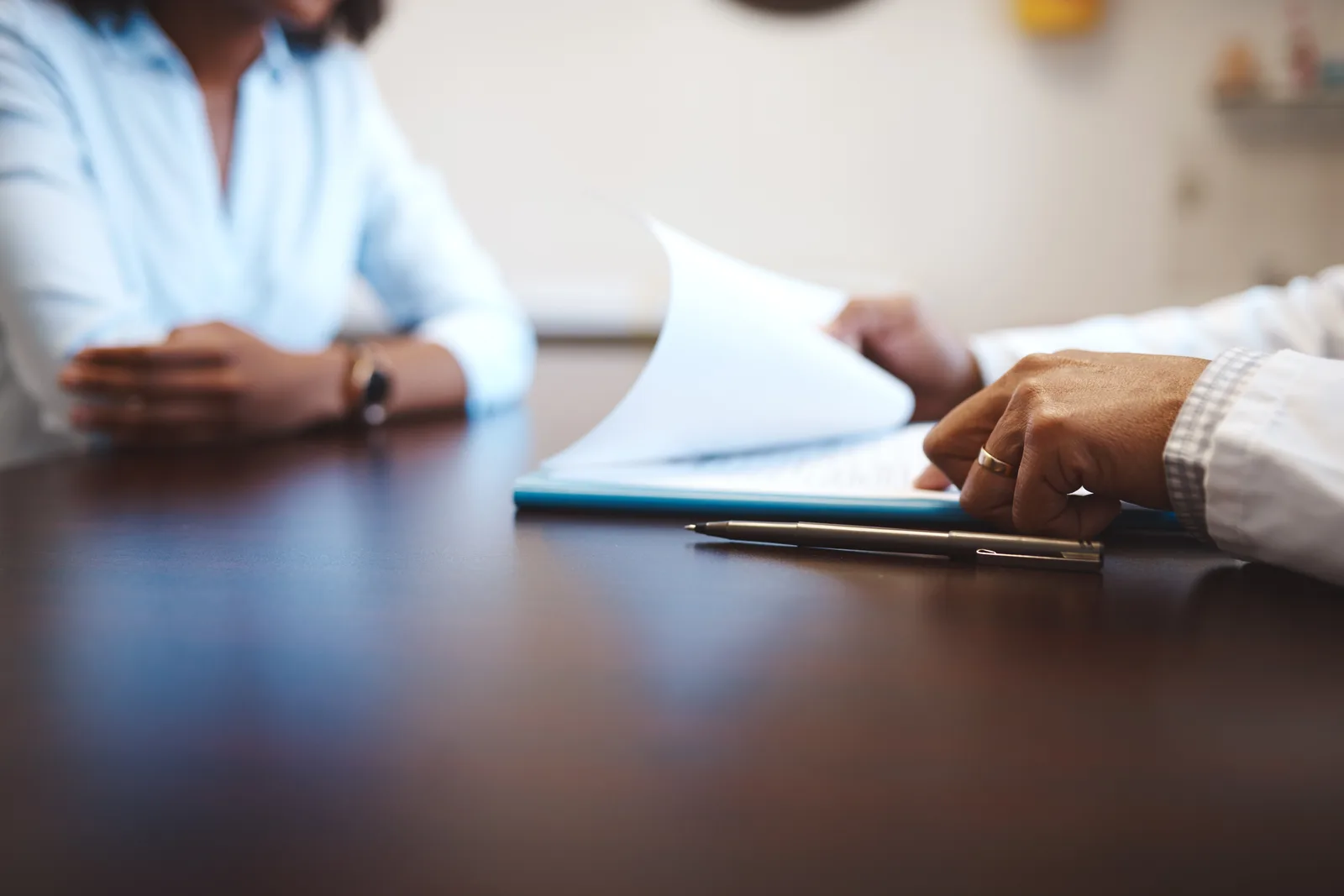 Insurance bad faith attorney at a conference table reviewing a client's denial letter and insurance policy with them