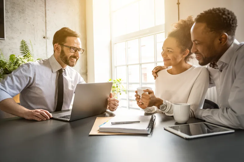Insurance agent reviewing coverage options with a couple in an office