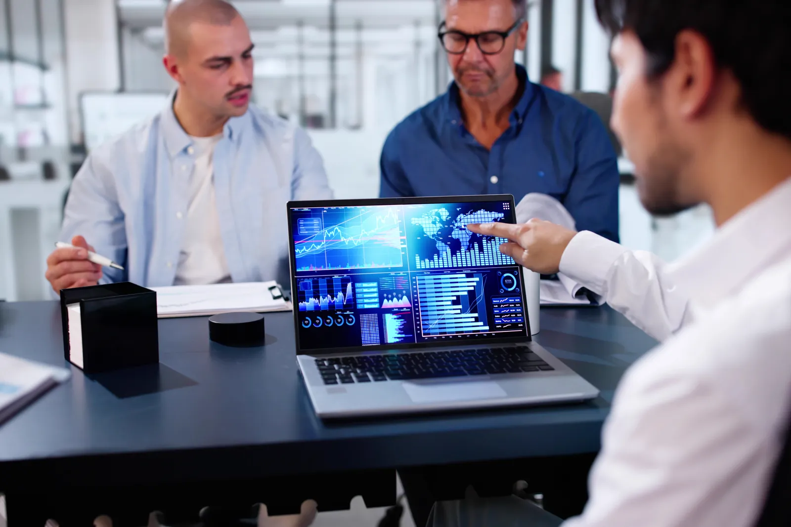 Insurtech product team reviewing an underwriting and policy dashboard together on a laptop in their office