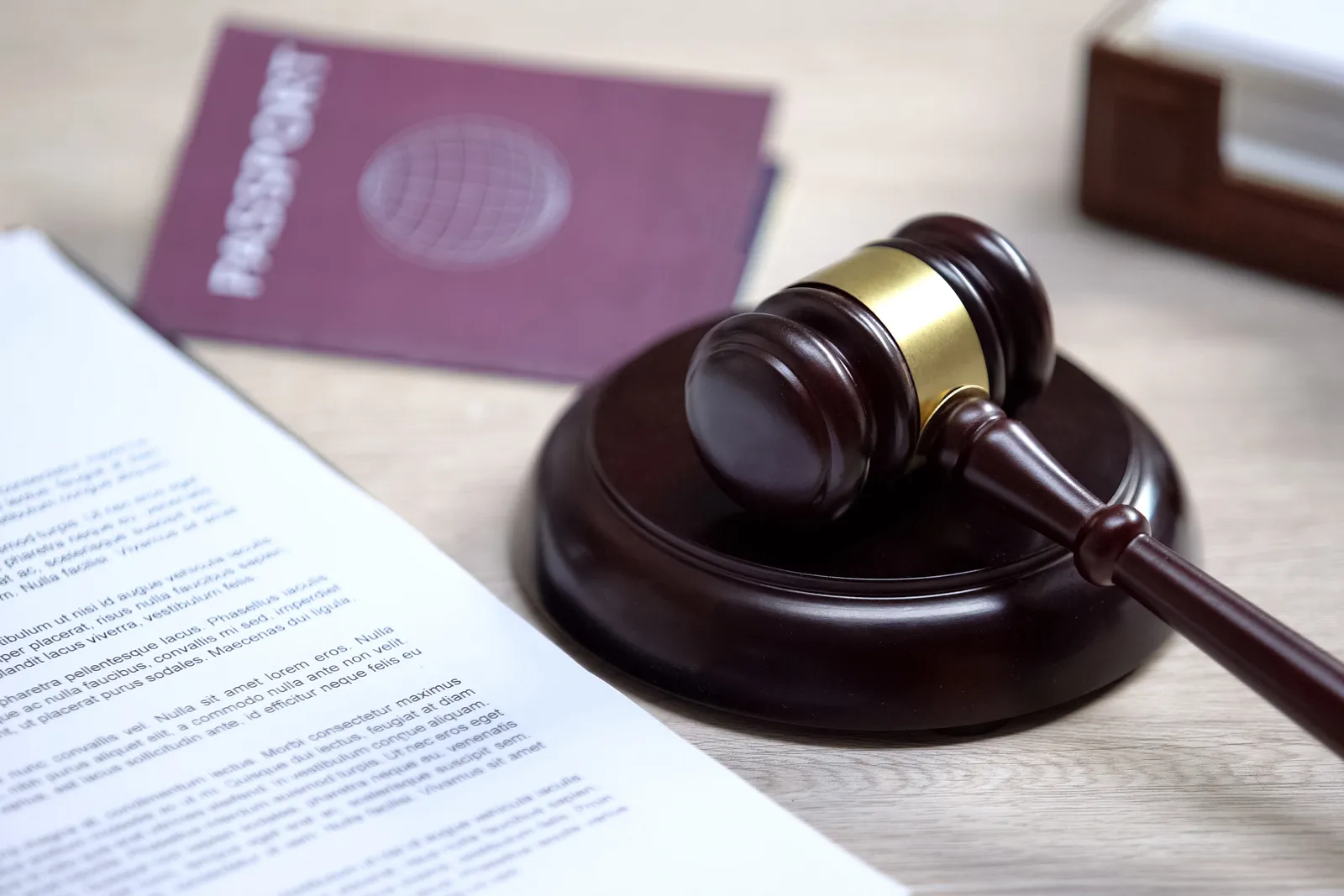 Passport and legal documents beside a gavel on an attorney's desk