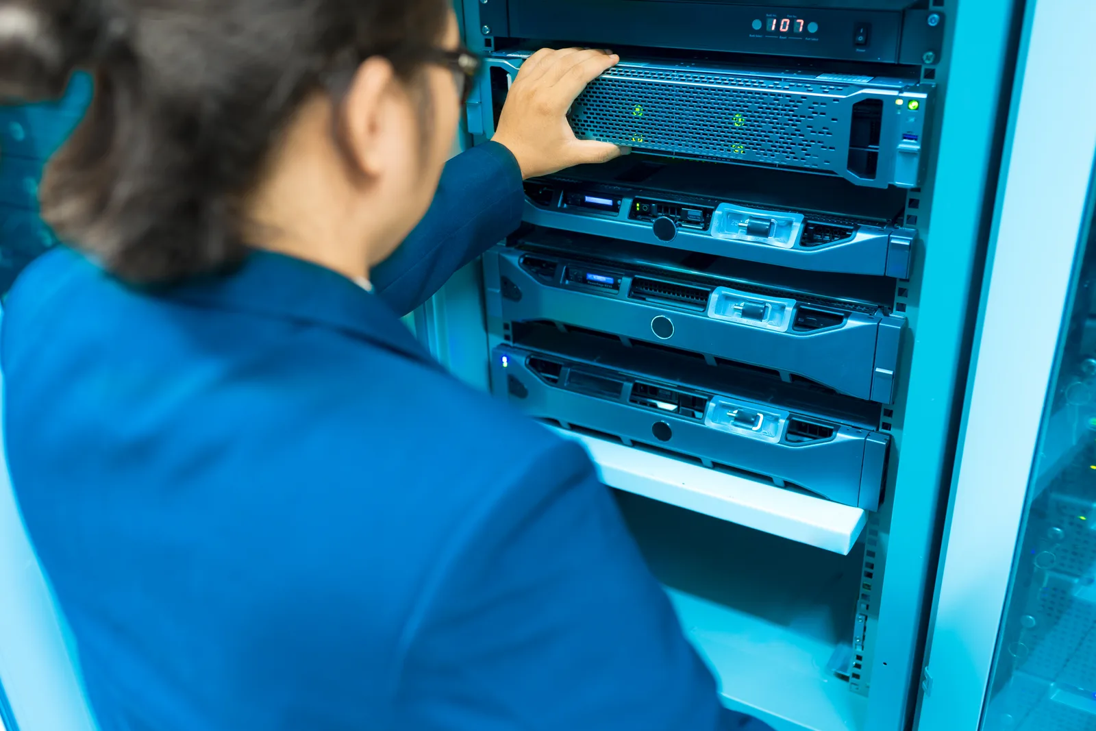 IT support technician working on server and network equipment in a small business server closet