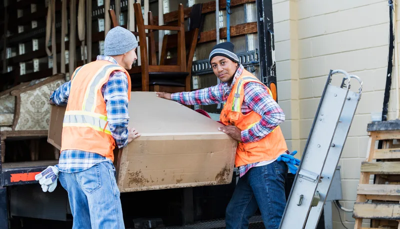Junk removal crew loading items into a hauling truck