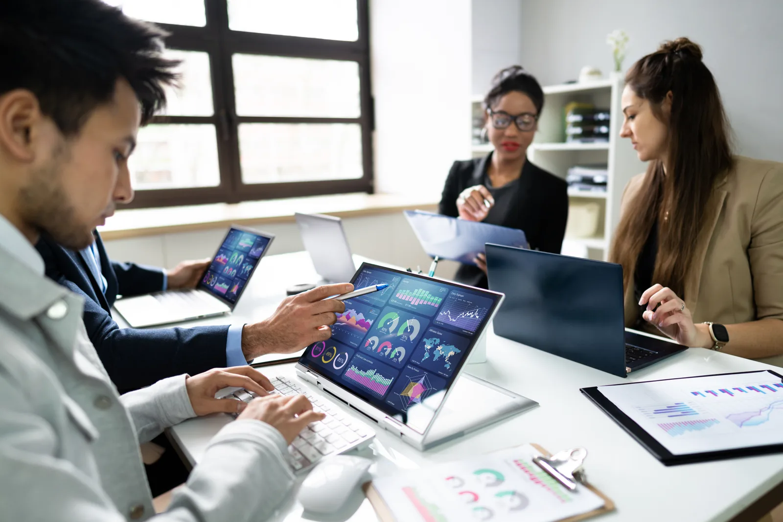 Legal software product team reviewing a case management and trust-accounting dashboard together on a laptop in their office