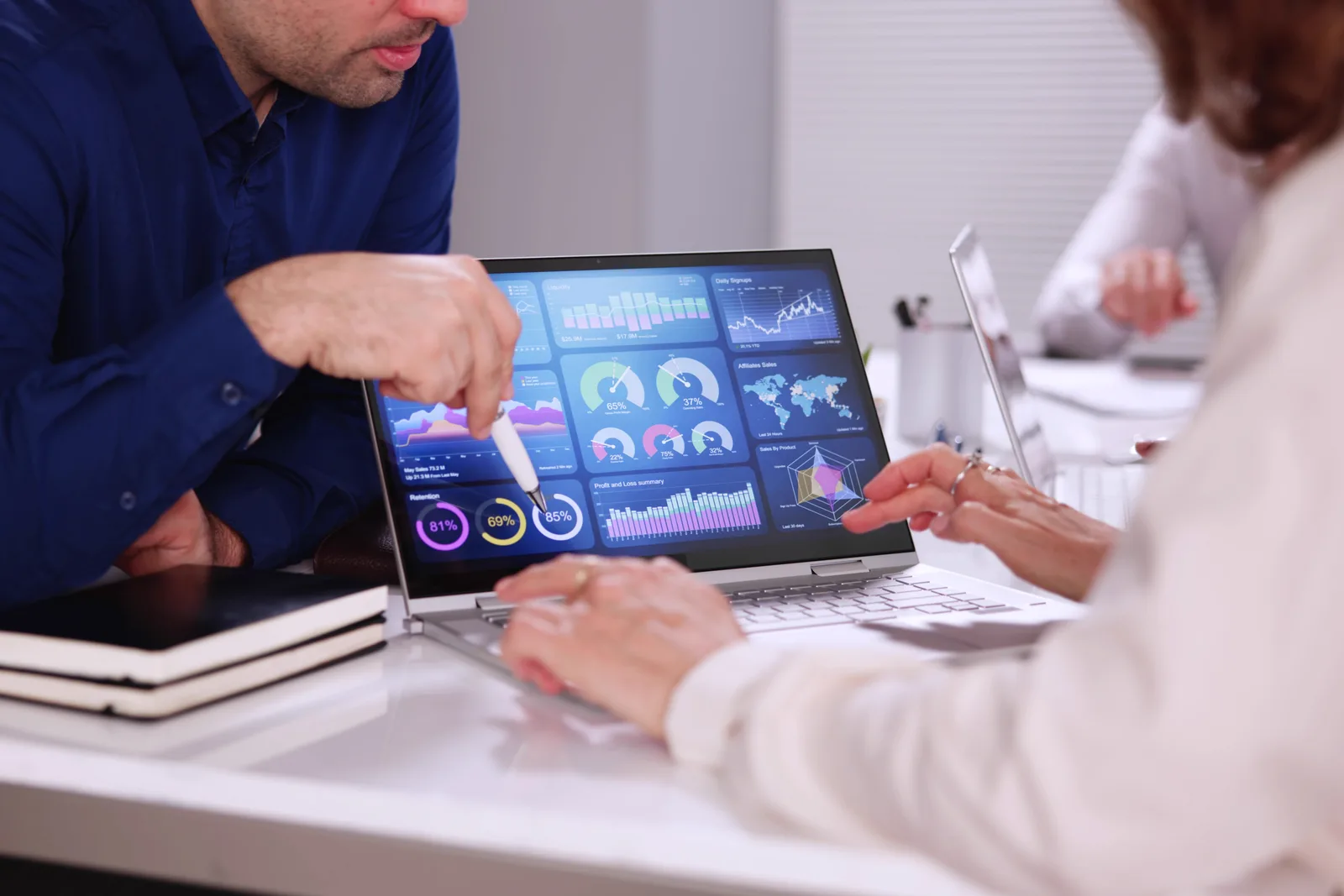 Legal tech product team reviewing a legal research and analytics dashboard together on a laptop in their office