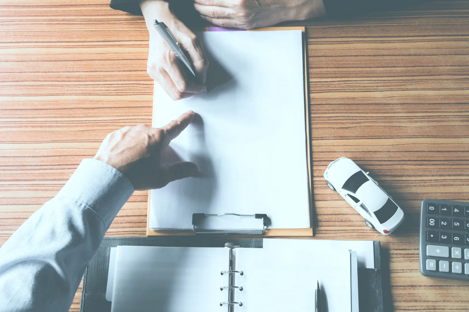 Lemon law attorney reviewing a client's vehicle repair order history and warranty paperwork during an in-office consultation