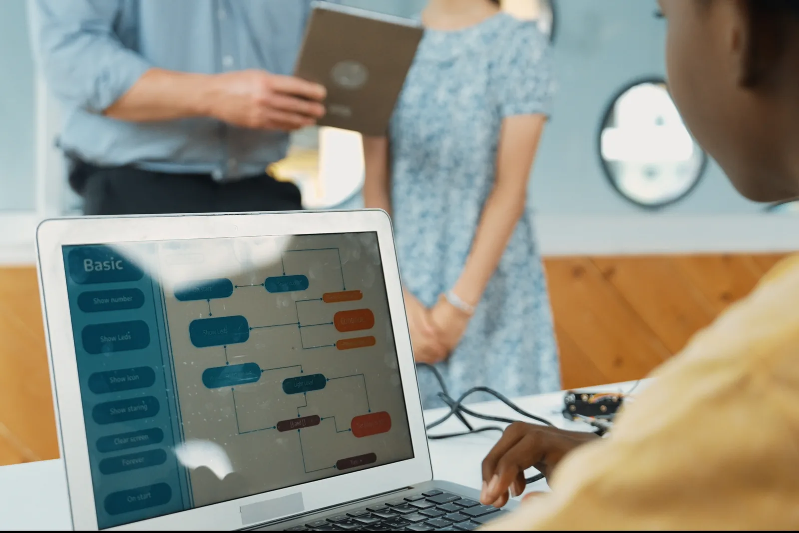 Customer engagement team reviewing a live chat conversation and chatbot flow together on a laptop screen in their office