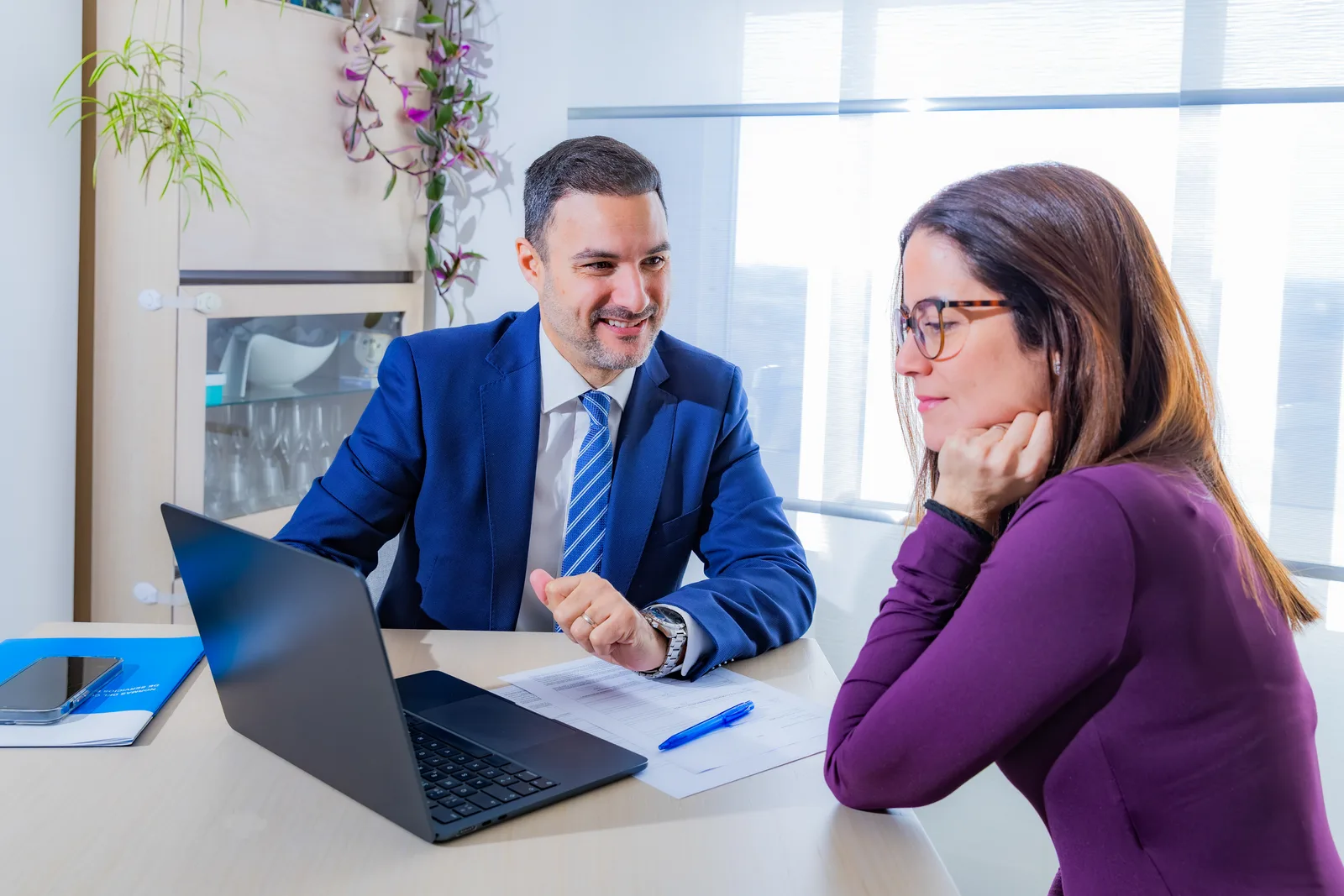 Mortgage operations team reviewing a loan origination software dashboard together at a desk