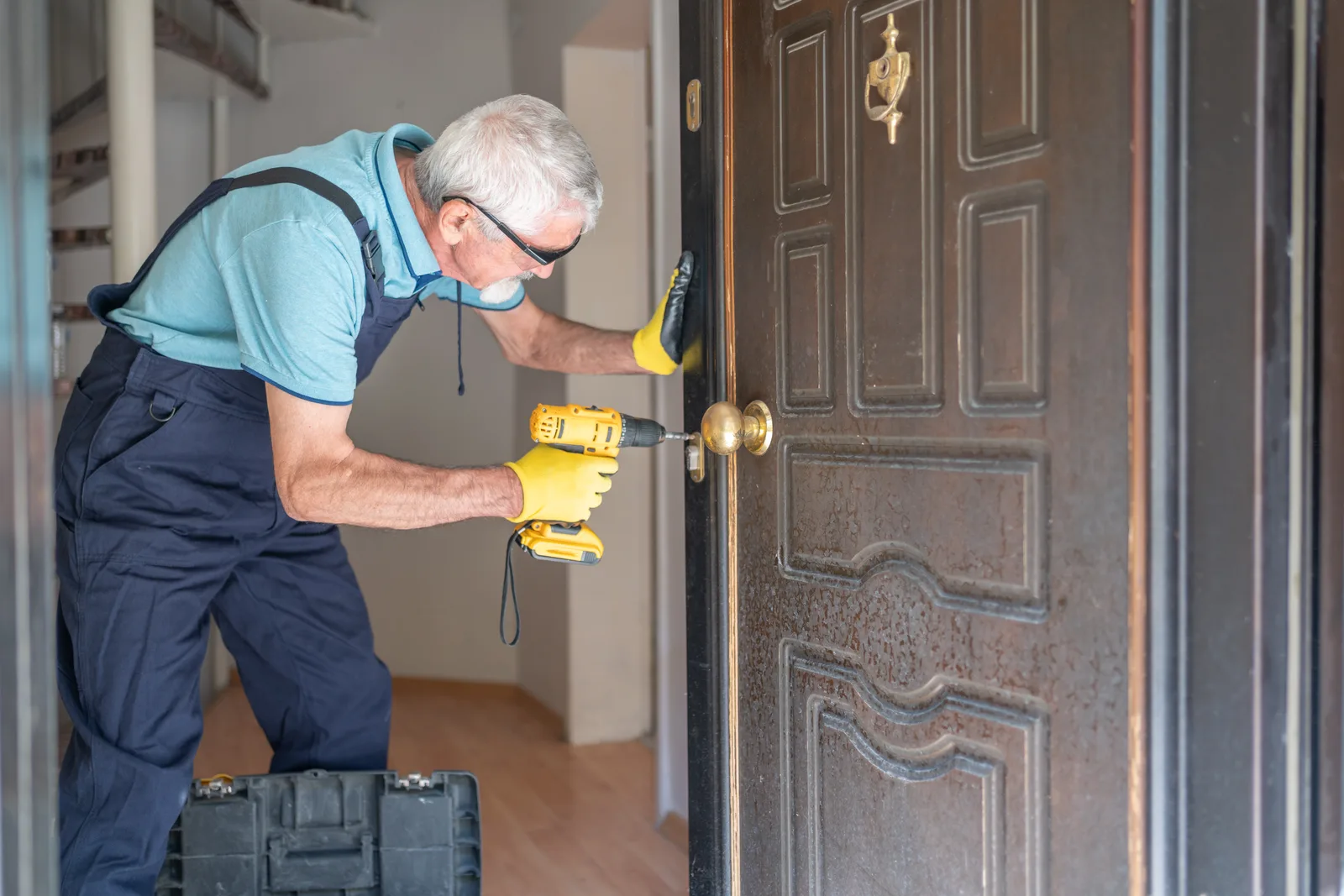 Locksmith fitting a new deadbolt on a customer's front door