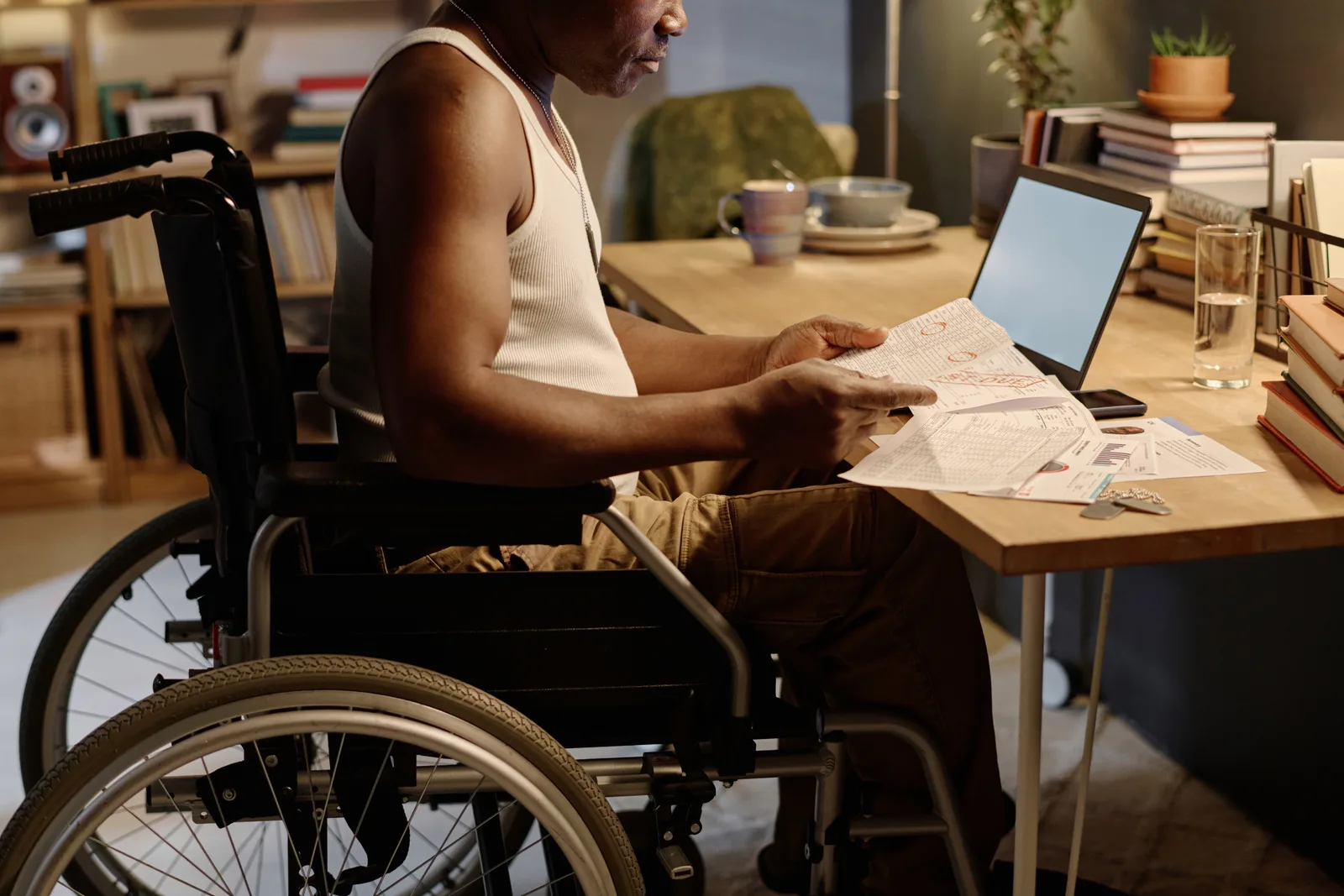 Long-term disability attorney reviewing an ERISA denial letter and appeal paperwork with a client at his office desk