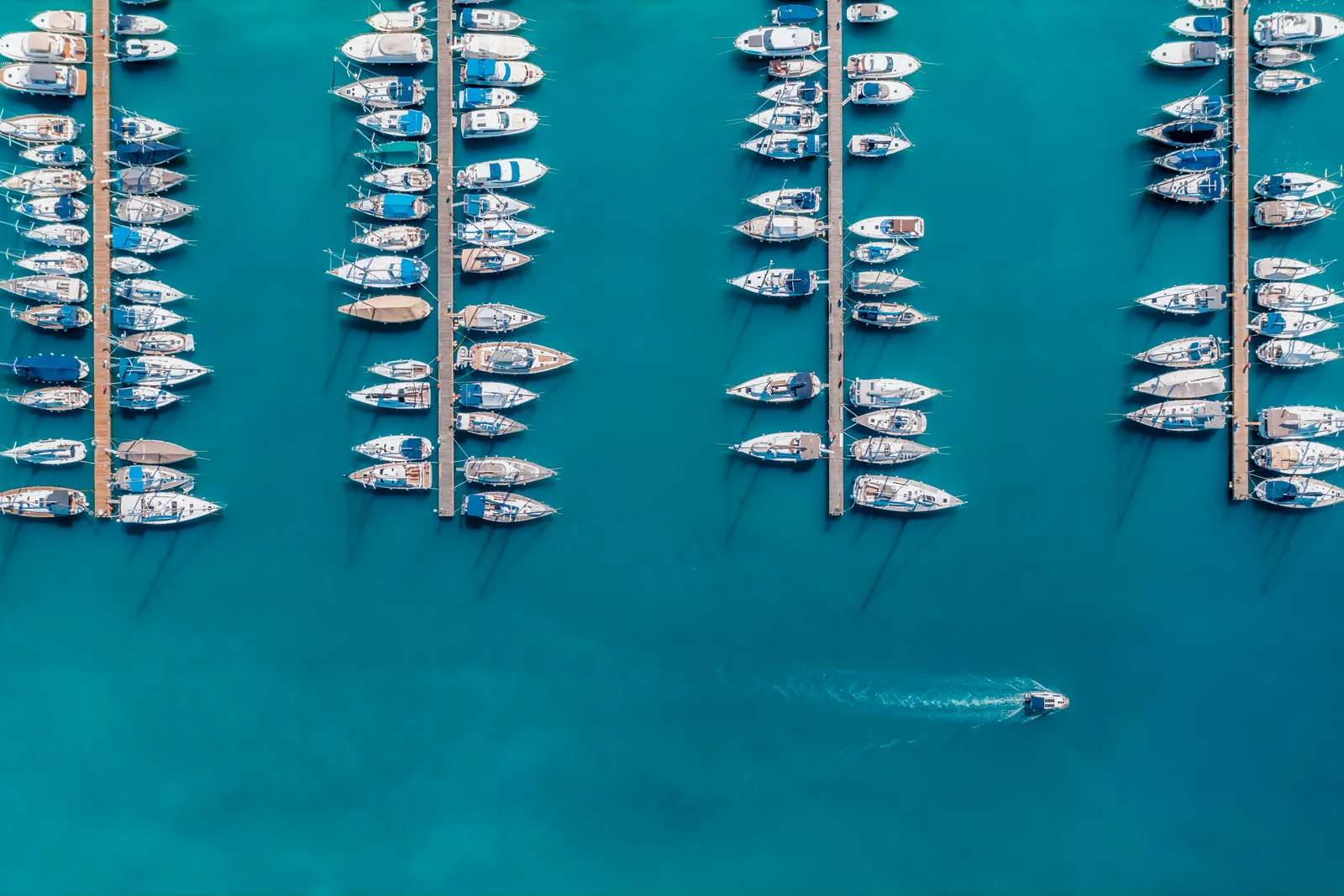 Aerial view of boats docked in rows of marina berths