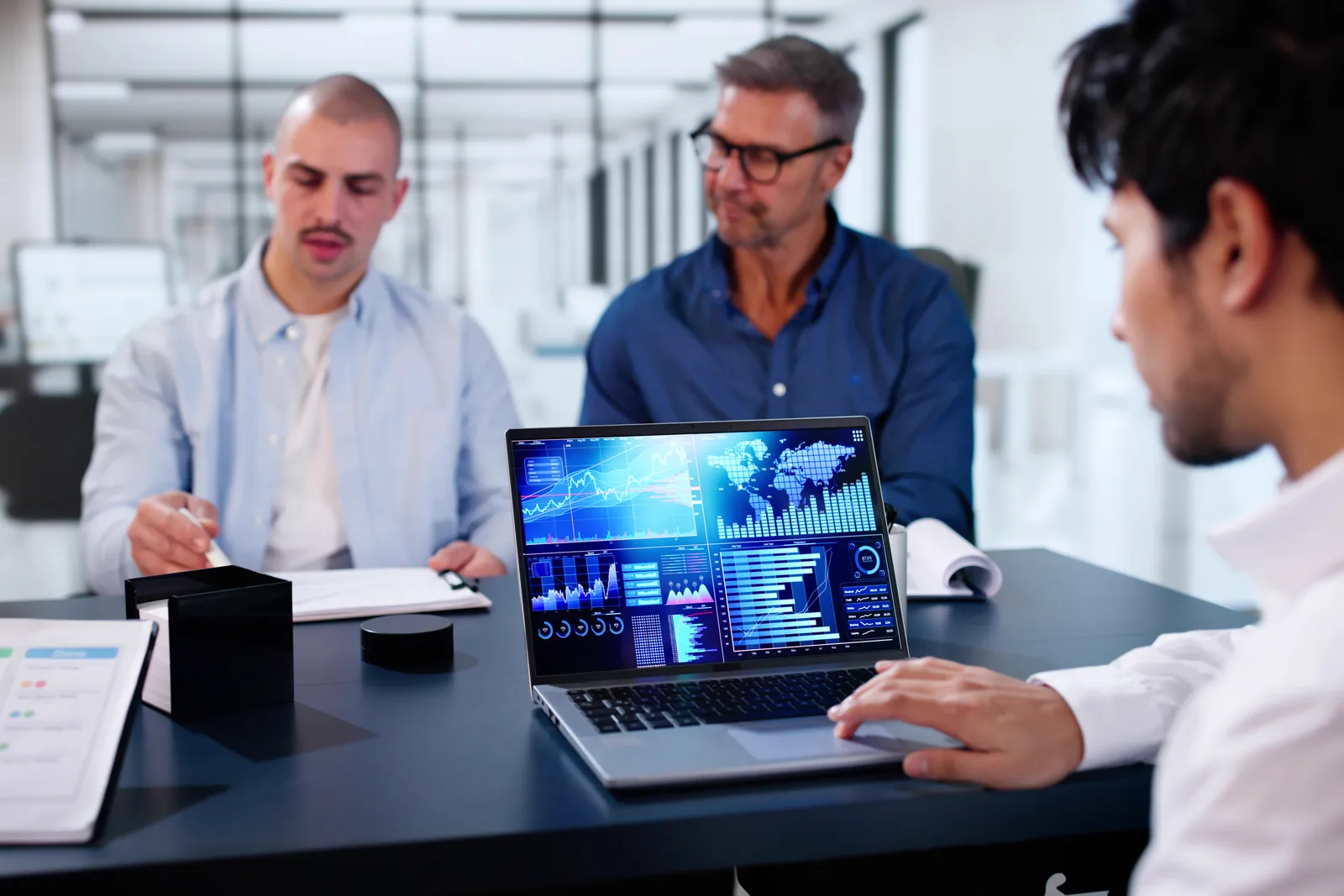 Marketing ops team reviewing trial-signup and workflow-activation data together on a laptop