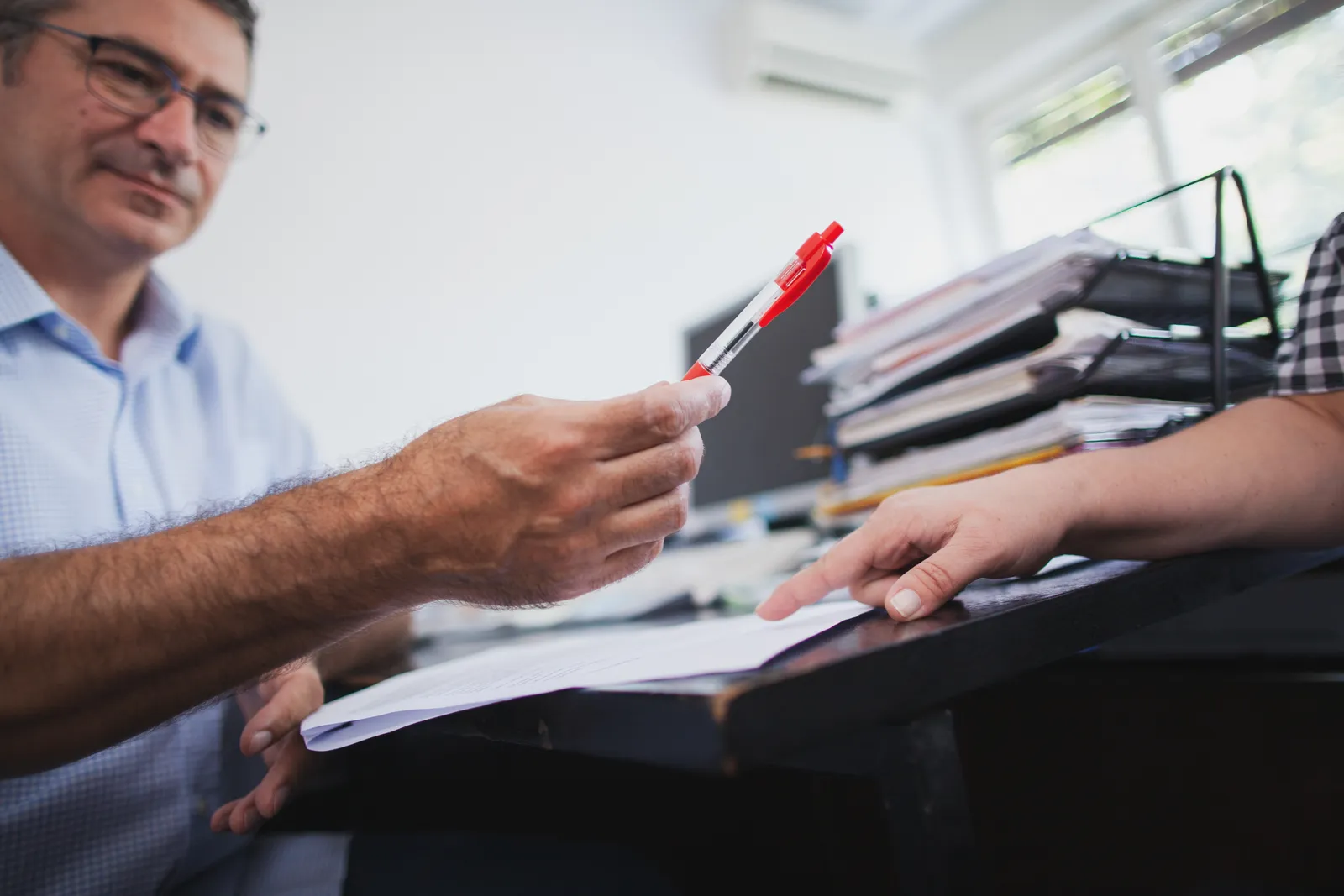 Media law attorney marking up a news story with an editor before publication, flagging a passage for legal review