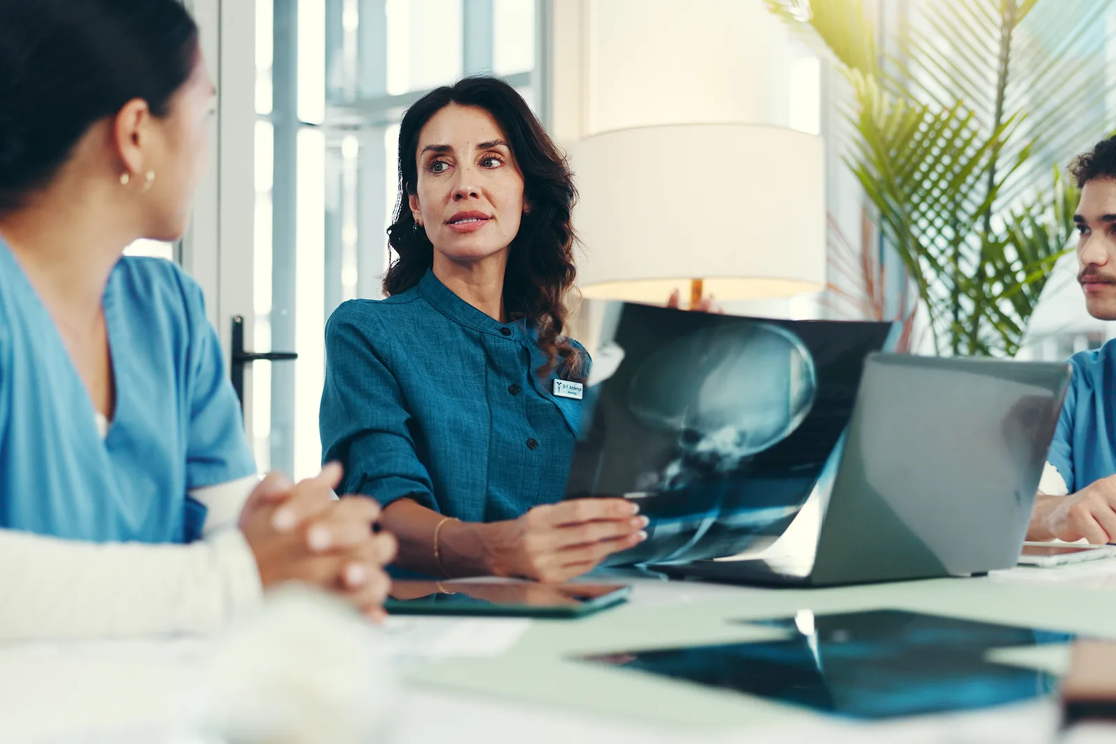 Medical device injury attorney reviewing hip implant X-ray images and surgical records with a client at a law office conference table