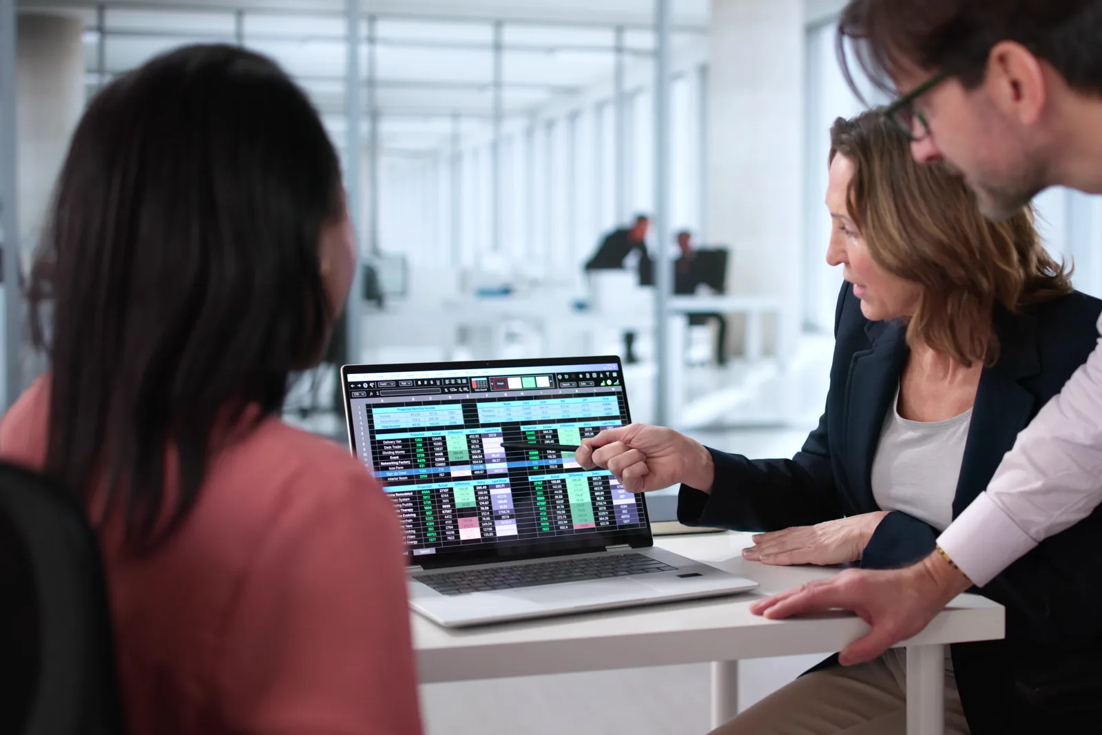 Medical imaging software product team reviewing a PACS worklist and DICOM image viewer dashboard together on a laptop in their office