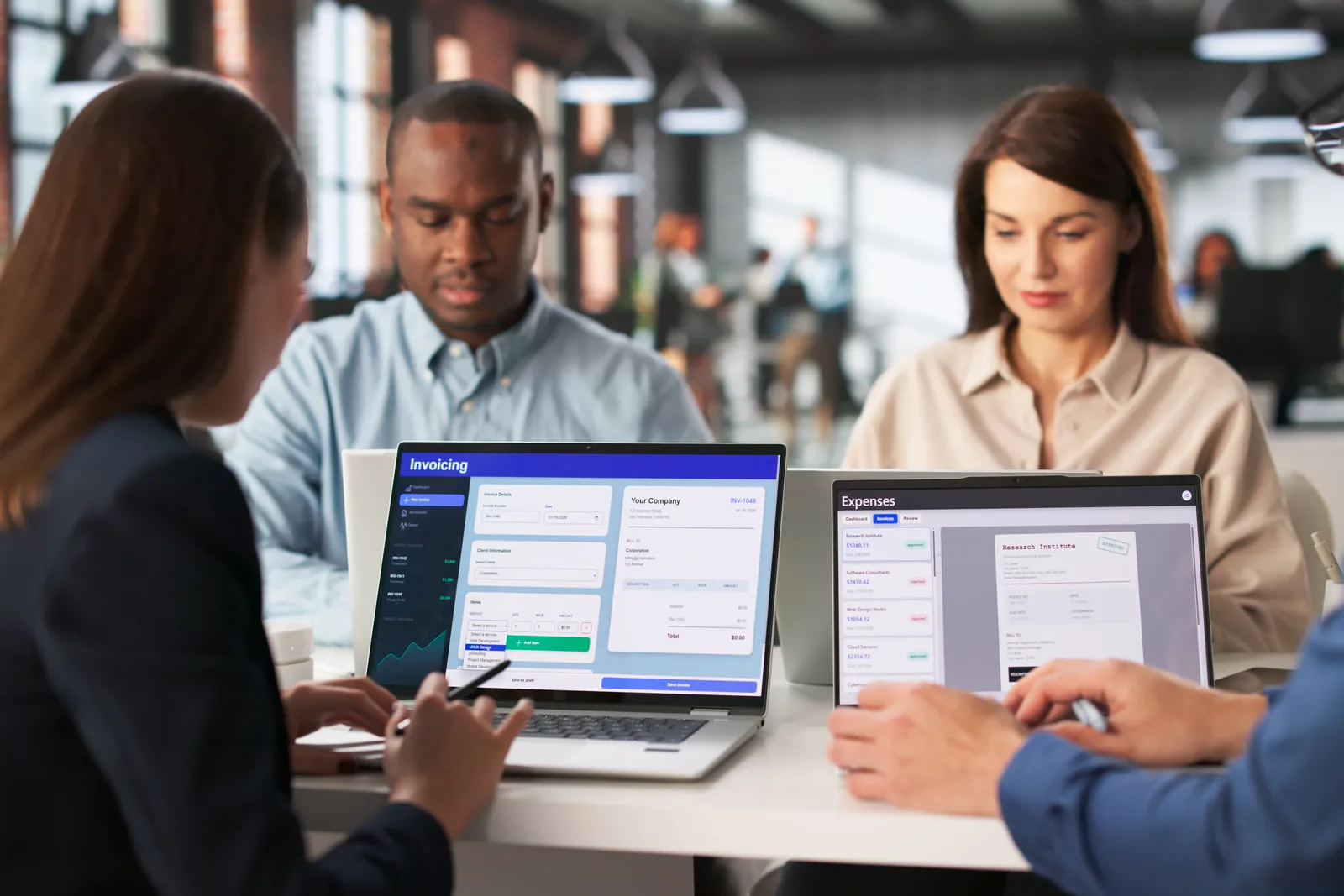 Software team reviewing a membership renewal and dues-billing dashboard together at a laptop in their office