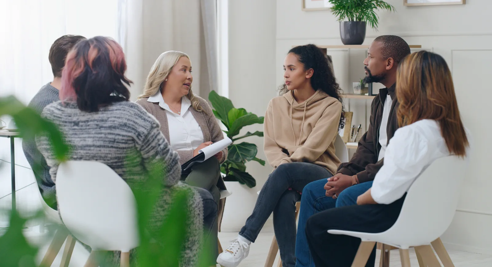 A clinician welcoming a client into a bright, calm office at a multi-clinician mental health clinic