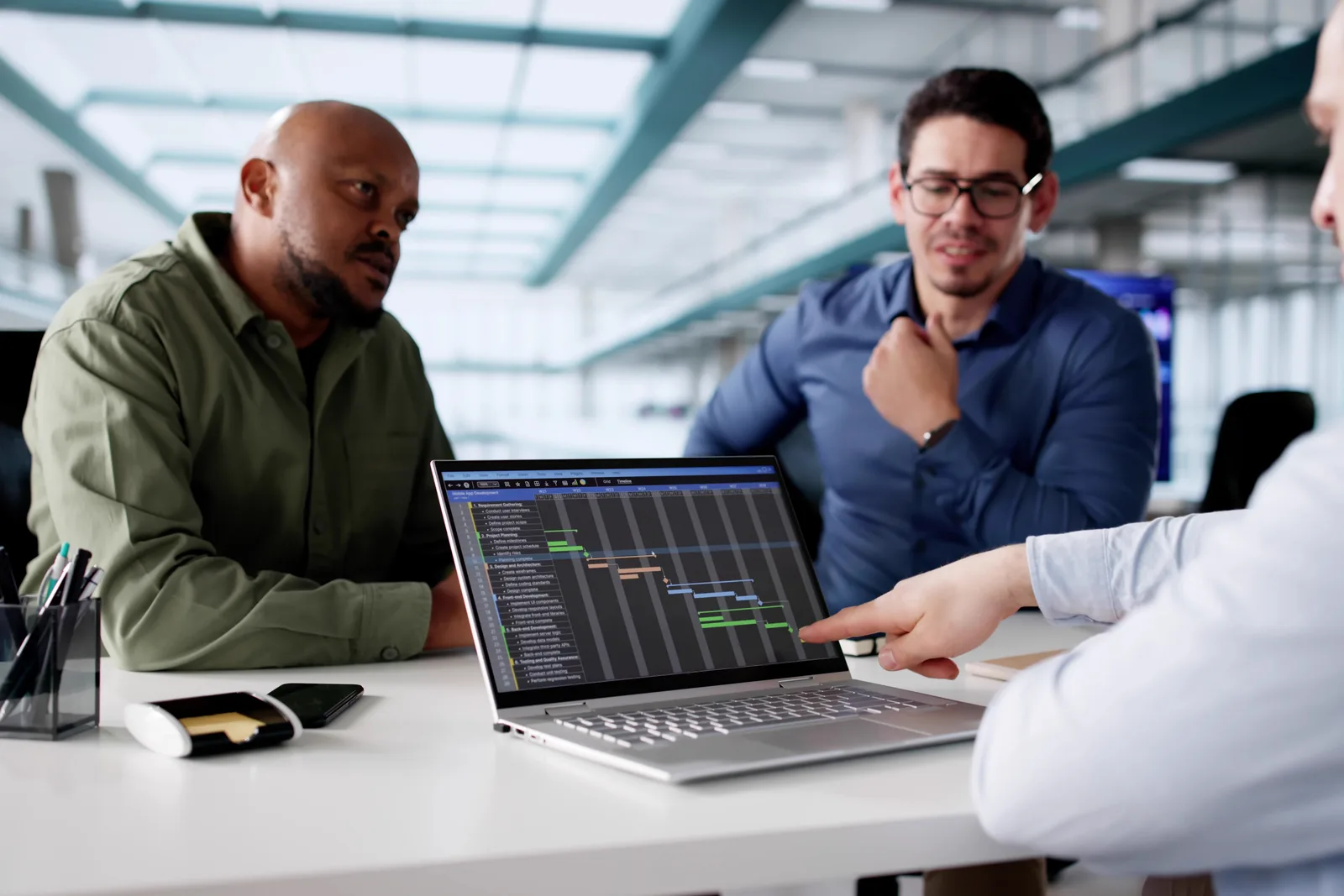 Mental health software product team reviewing a clinician's scheduling and billing dashboard together on a laptop in their office