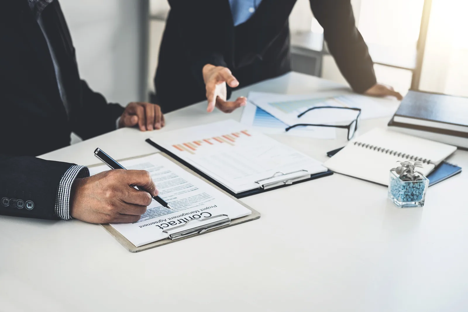 M&A attorney reviewing a purchase agreement with a business owner across a conference table